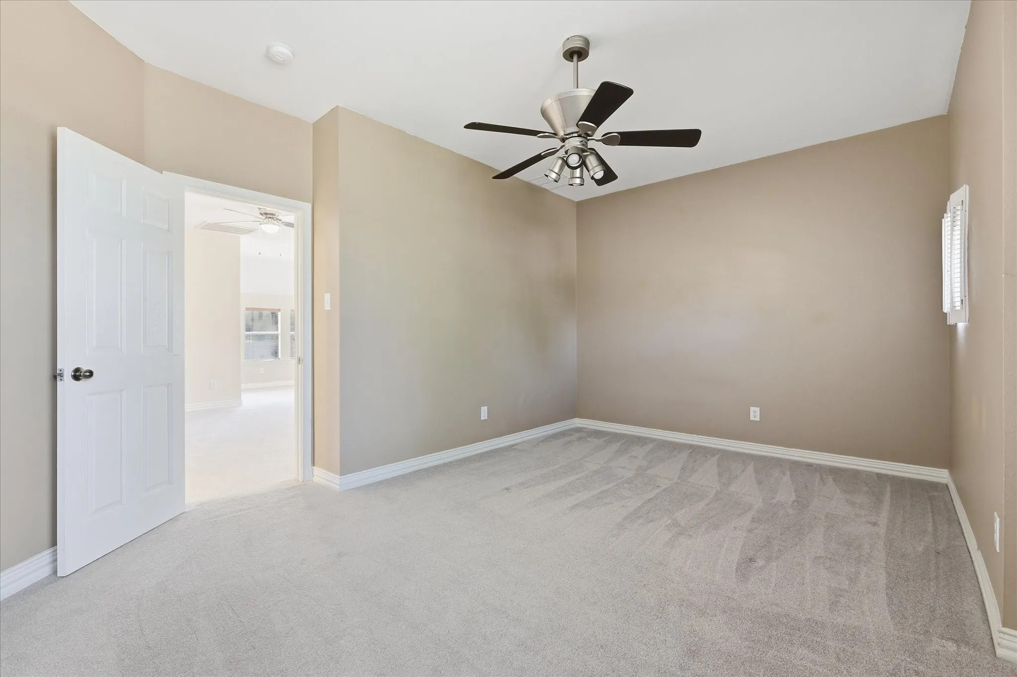 Bedoom featuring neutral-toned walls, light gray carpeting, and a ceiling fan with integrated lighting