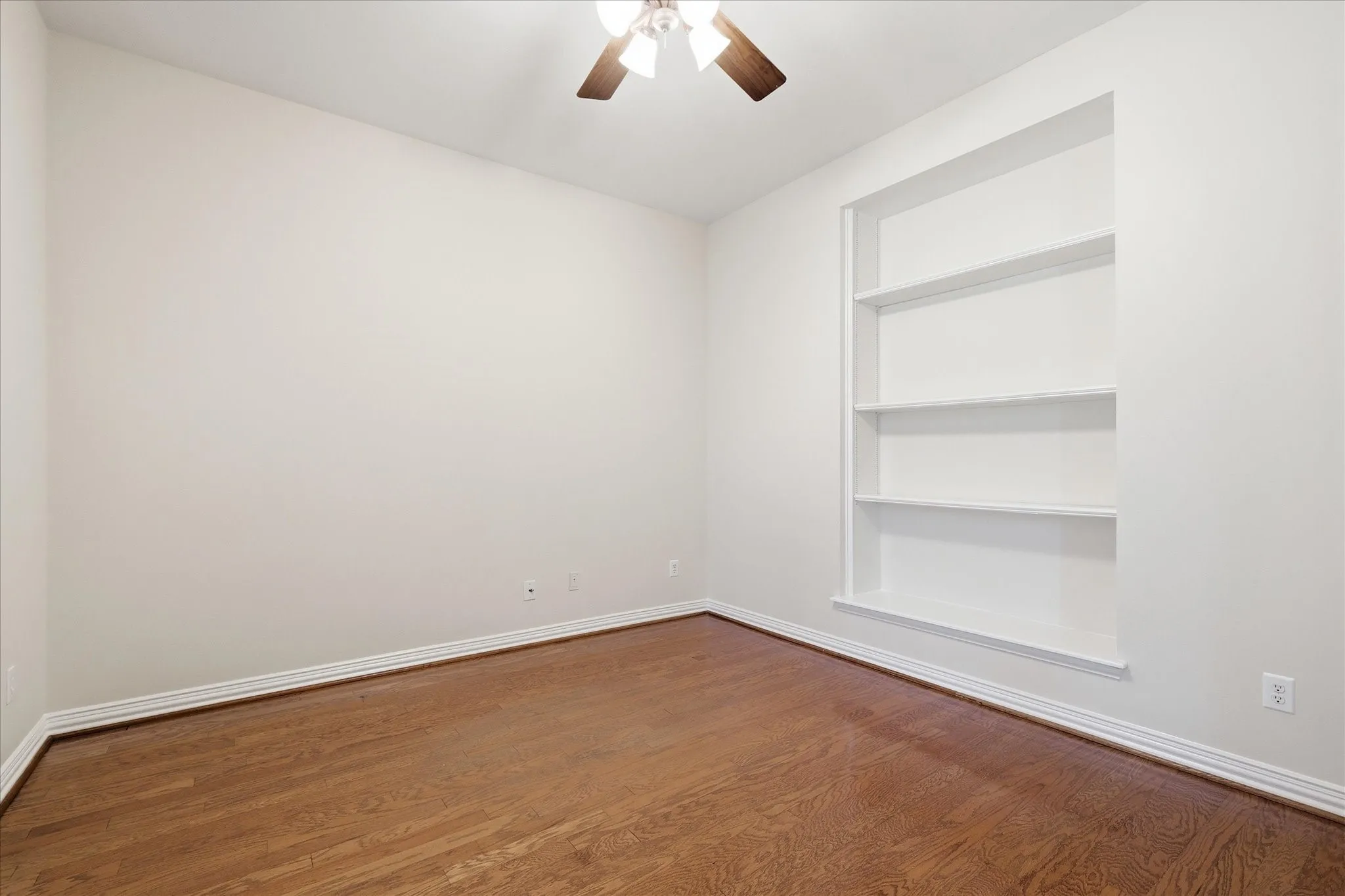Bright room featuring wood-finish flooring, white baseboards, and neutral wall tones