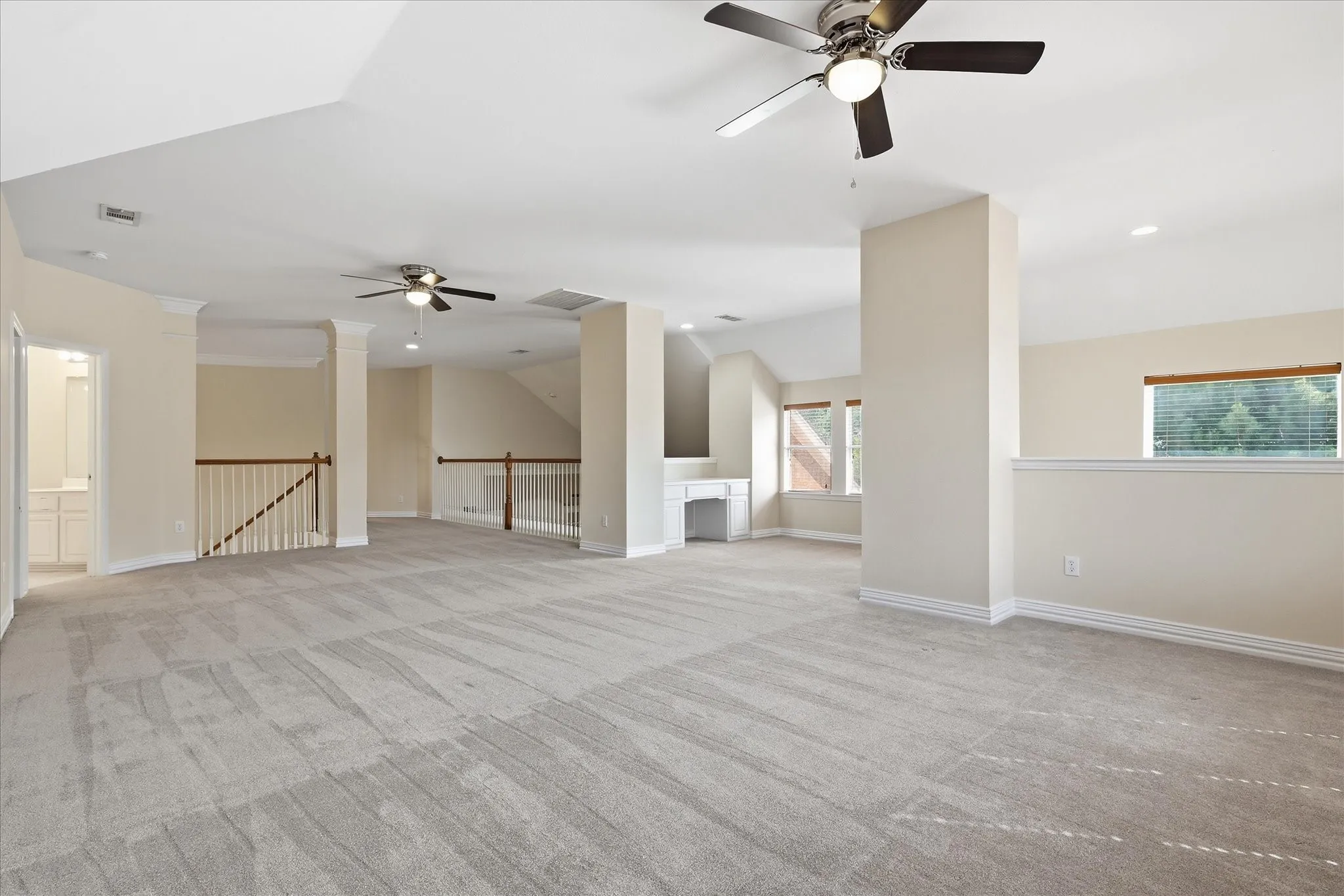 Open-concept Game room featuring neutral-toned walls, light grey carpeting, and a ceiling fan with integrated lighting. Also featuring an overlook open to the living room.