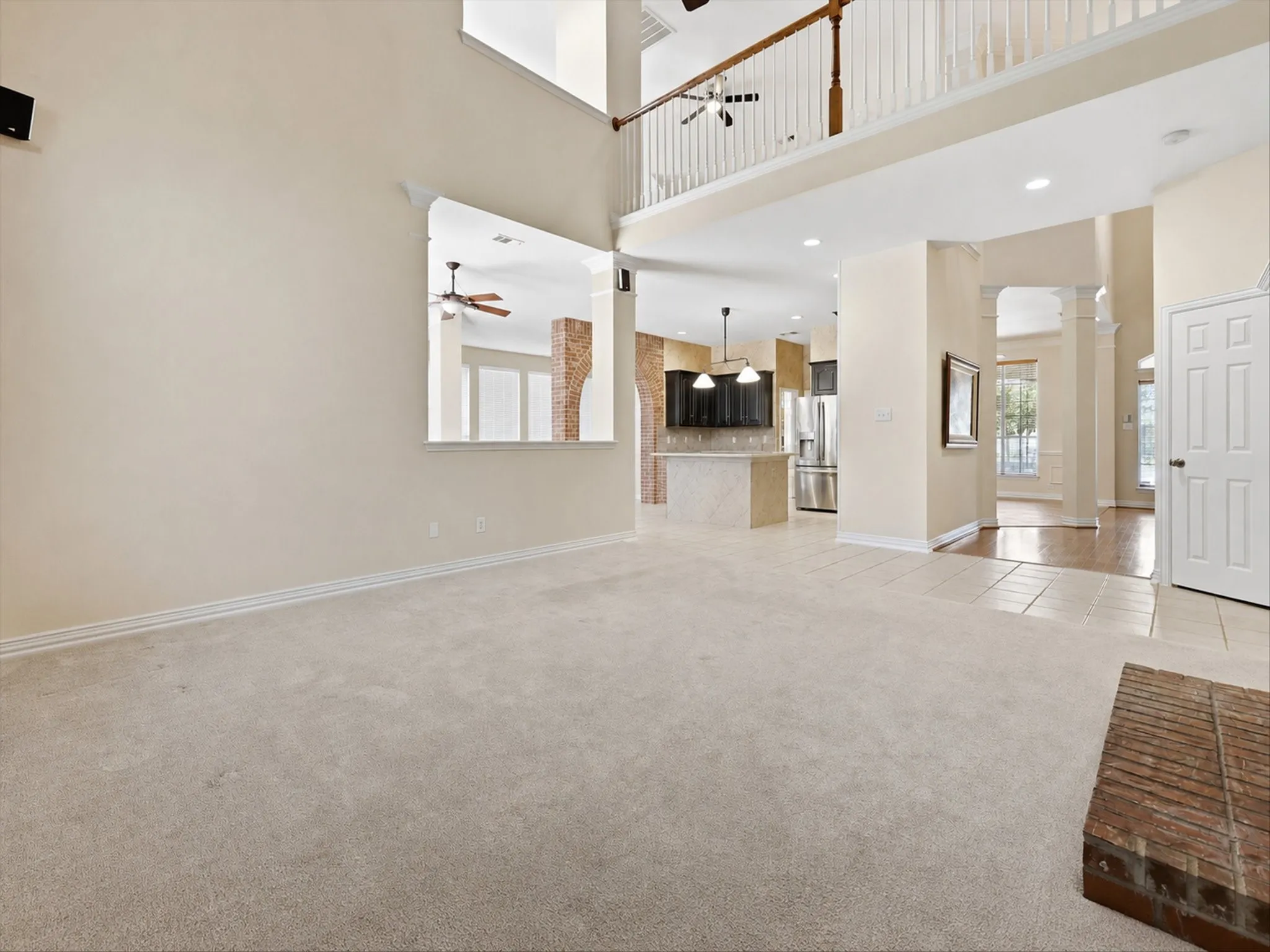 Living room with high ceilings, and light-toned carpeting