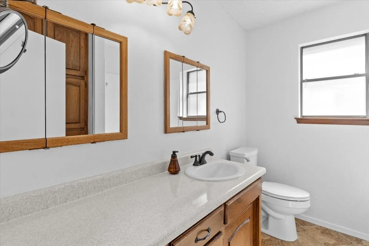 Bathroom vanity featuring a white sink, dark-toned faucet, and light-colored countertop