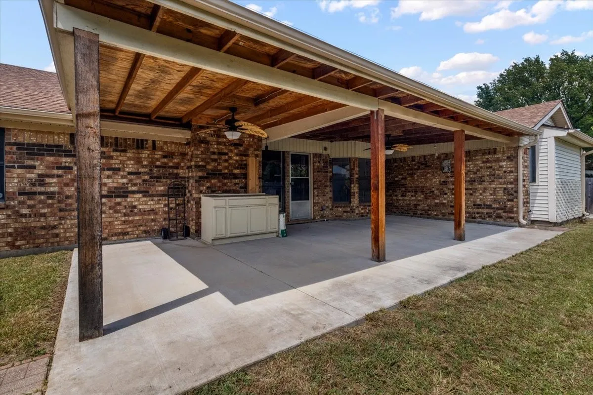 Covered patio with a concrete slab and wood-finish support beams