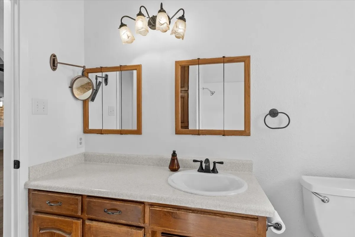 Bathroom vanity featuring a light-toned countertop with an integrated sink and dark-finish faucet