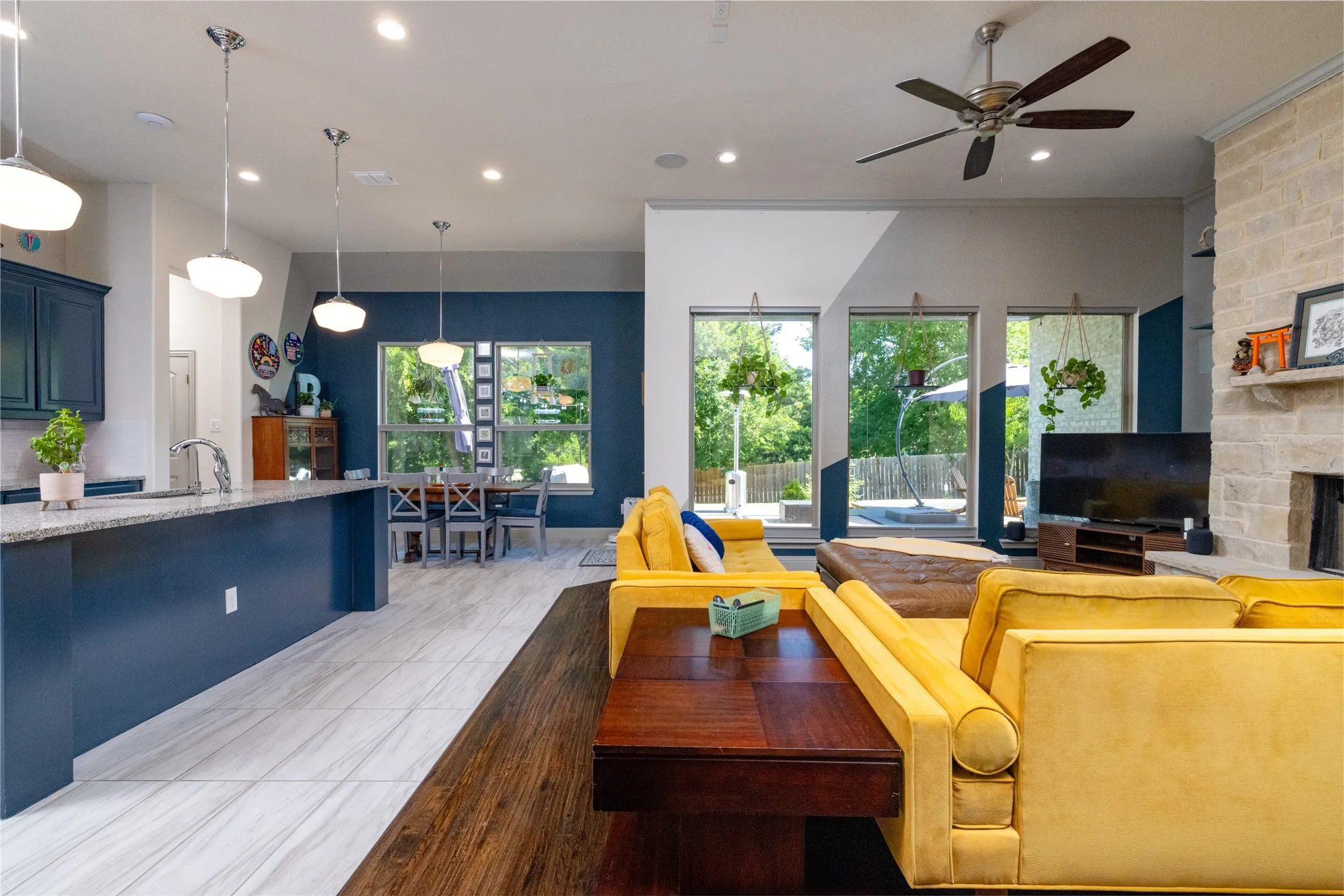 Open concept kitchen/living/dining with abundant windows and wood burning fireplace