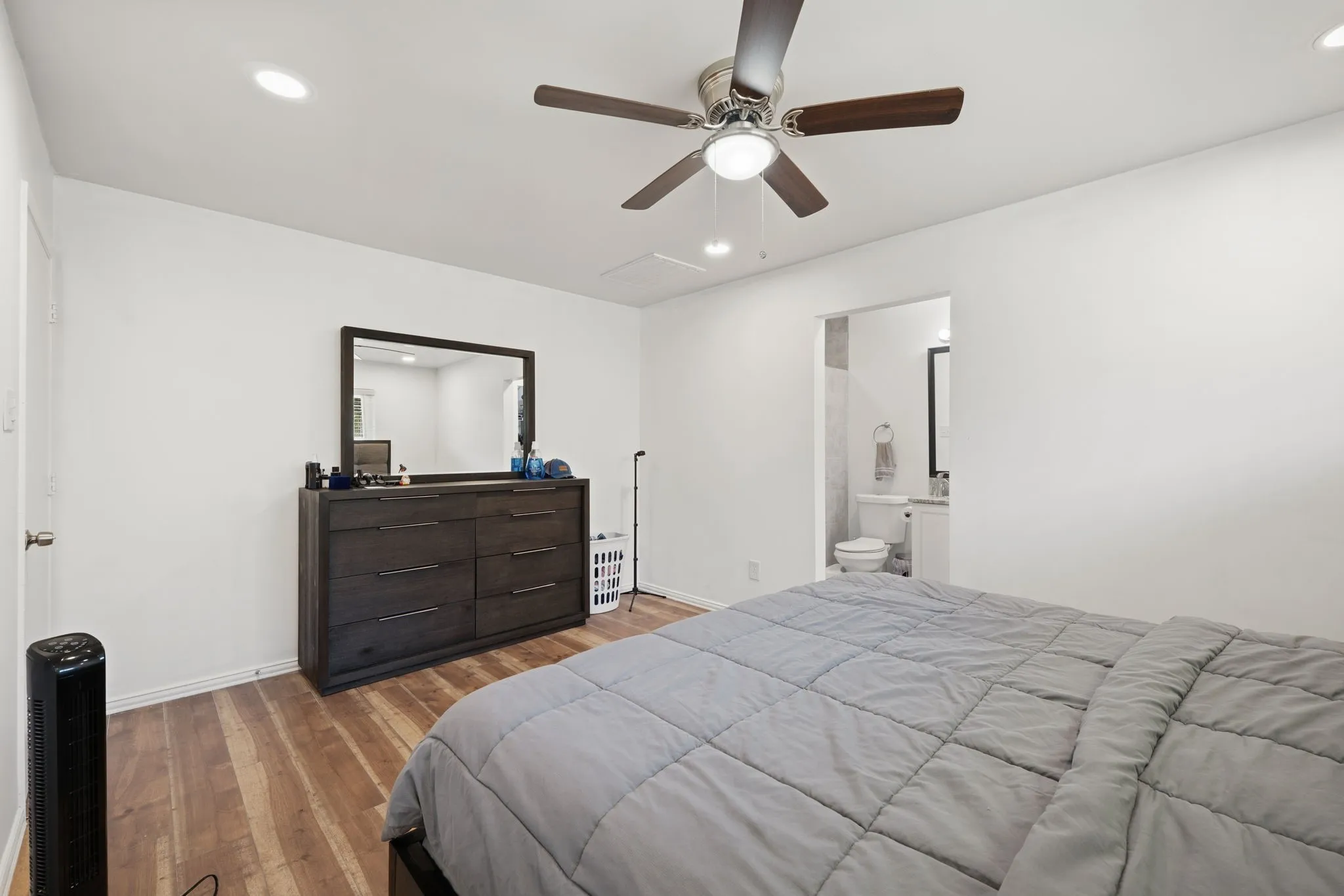 Wood-finish flooring throughout, recessed ceiling lighting, and a ceiling fan with light fixture