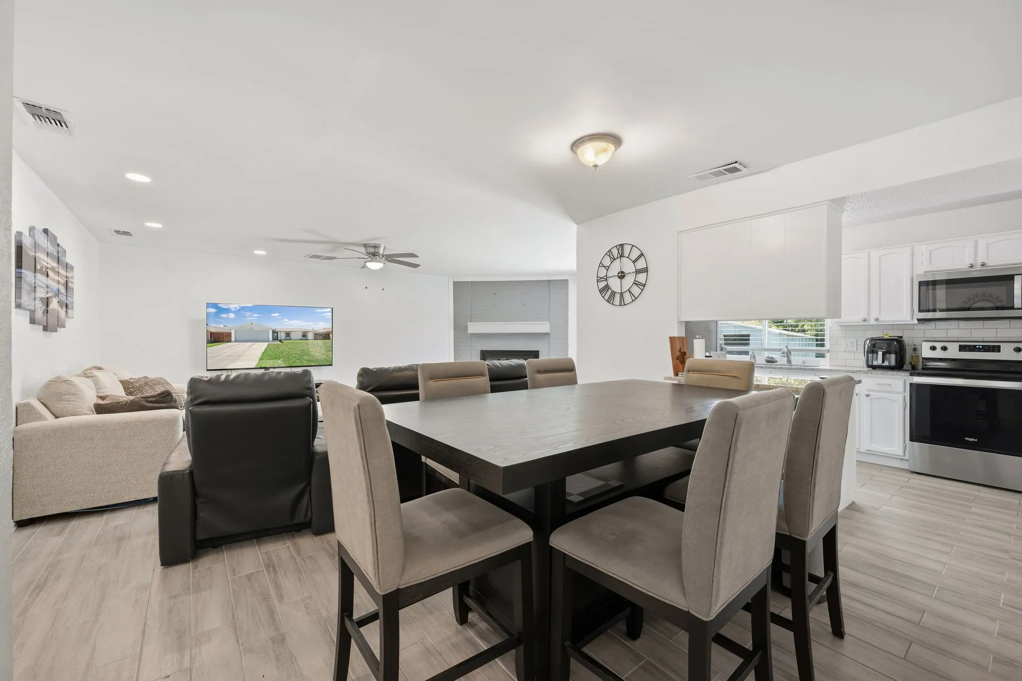 Open-concept living space featuring wood-finish flooring, recessed lighting, and a neutral color palette
