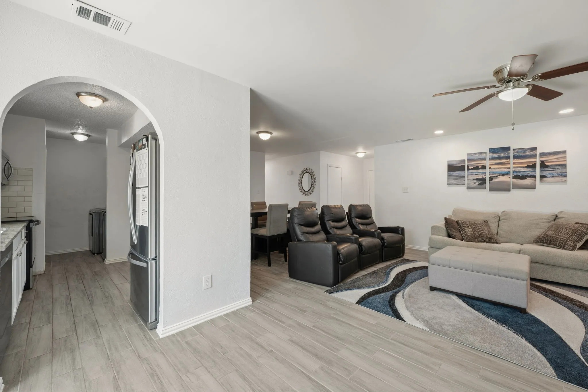 Open concept living area featuring light wood-finish flooring, recessed lighting, and a ceiling fan with integrated light