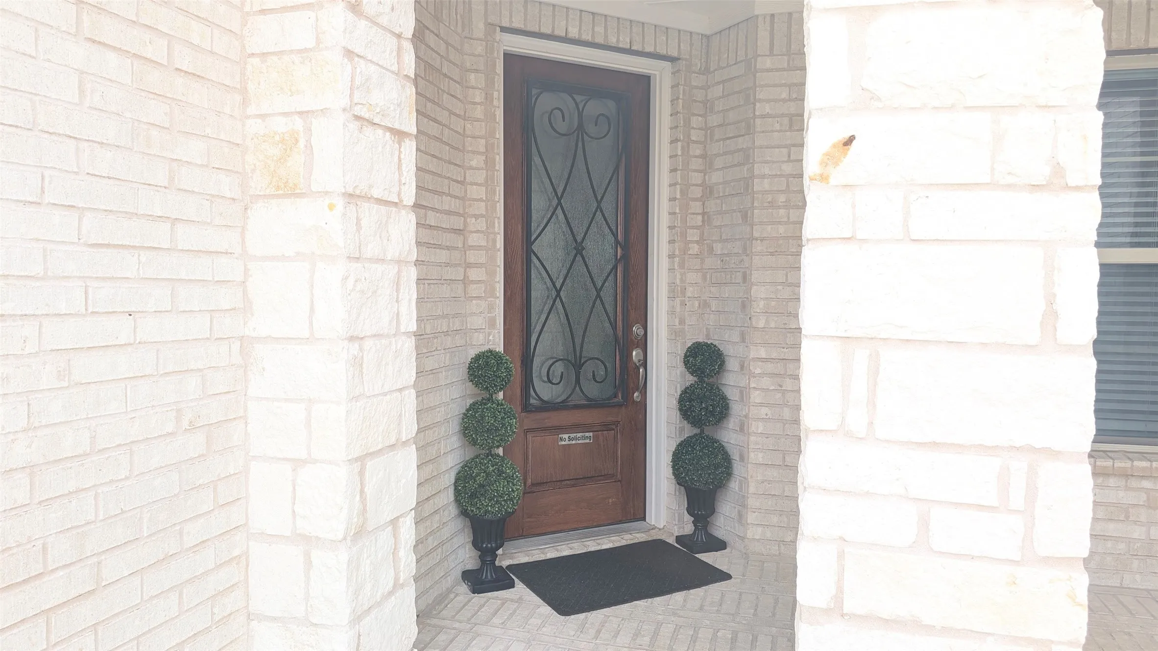 Wood-paneled entry door with decorative ironwork