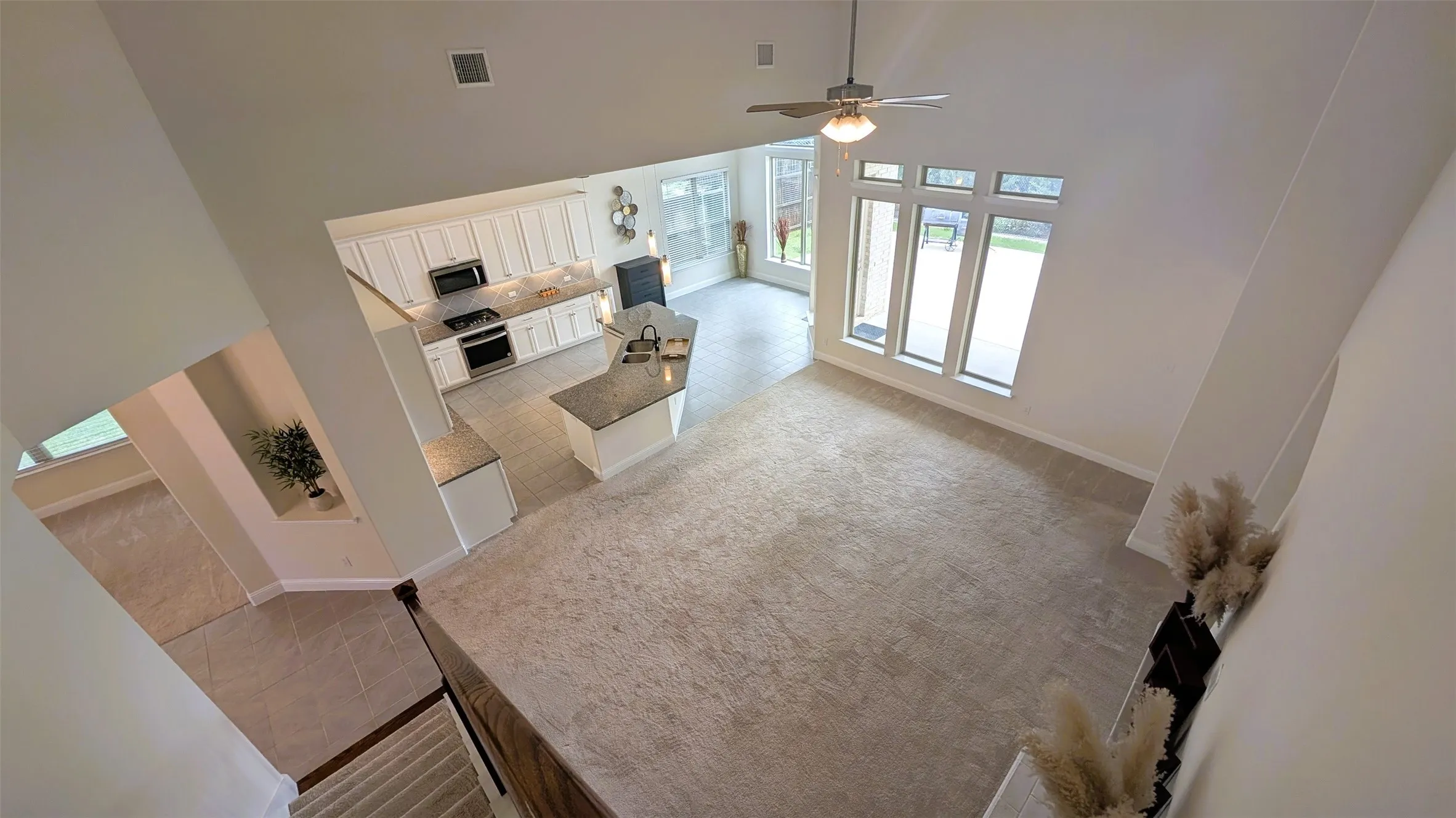 Open-concept living area featuring high vaulted ceilings and a ceiling fan