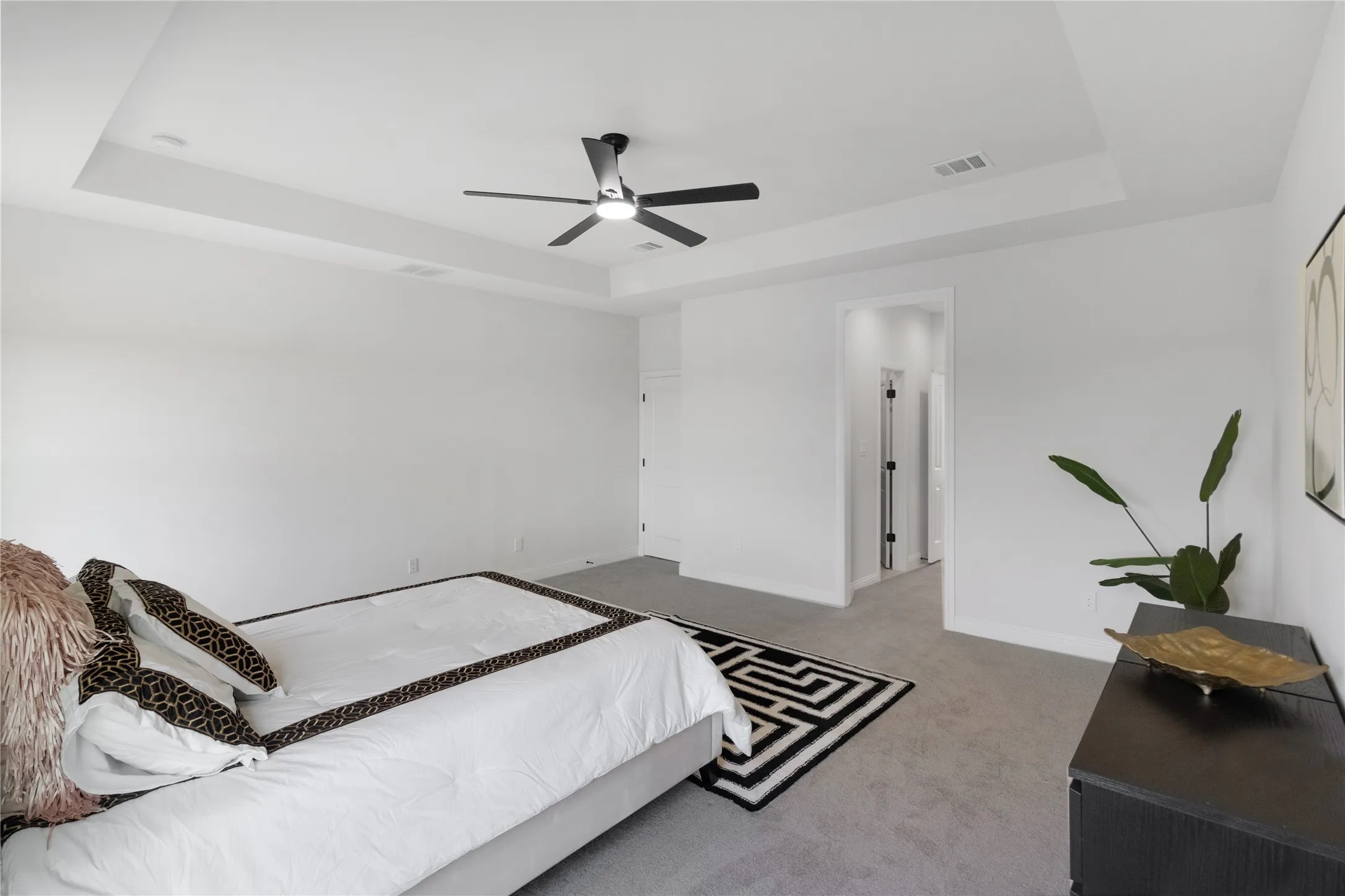 Recessed ceiling with a modern black ceiling fan and integrated lighting