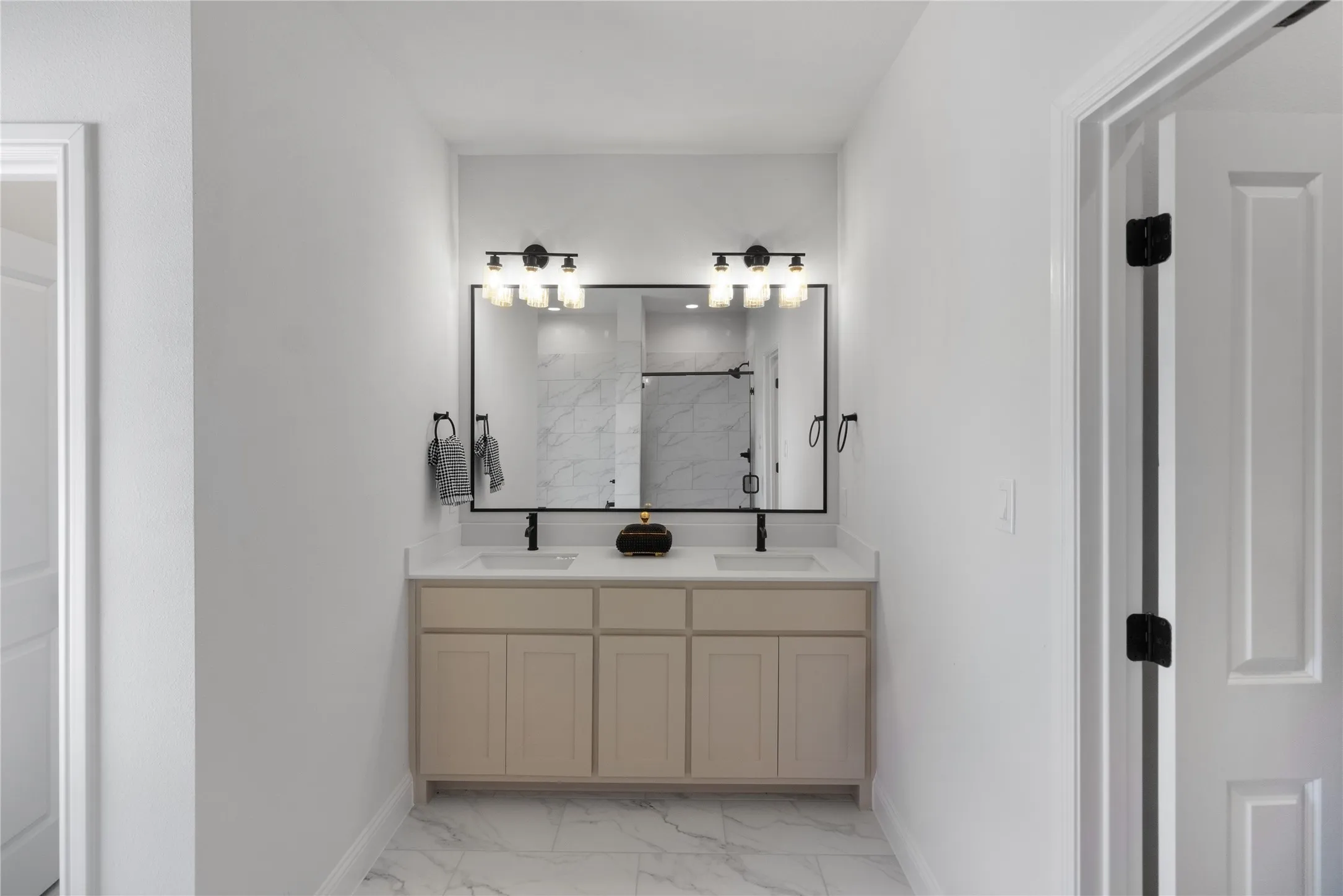 Dual sink vanity with light cabinetry and white countertops