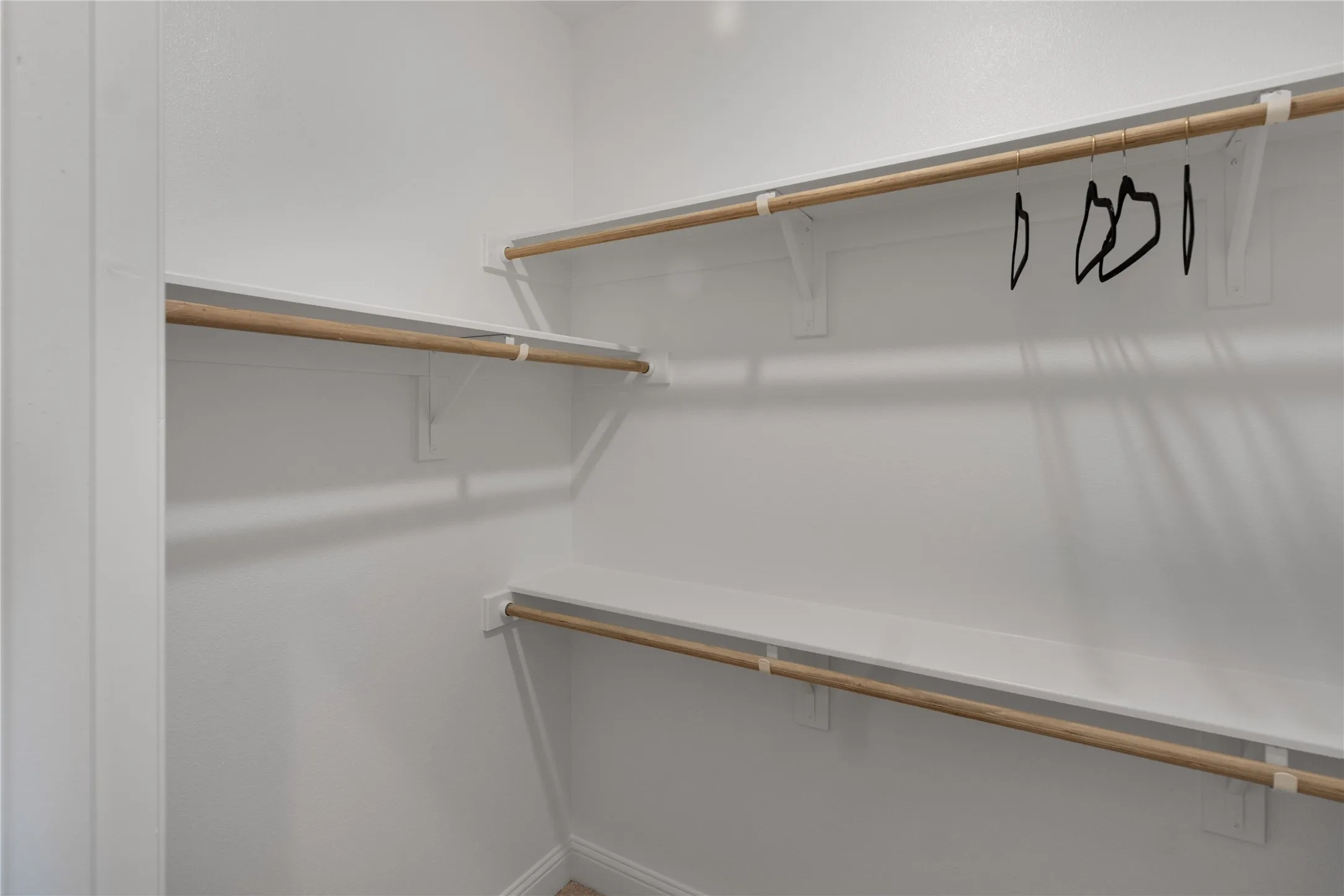 Closet featuring multiple levels of shelving and clothing rods