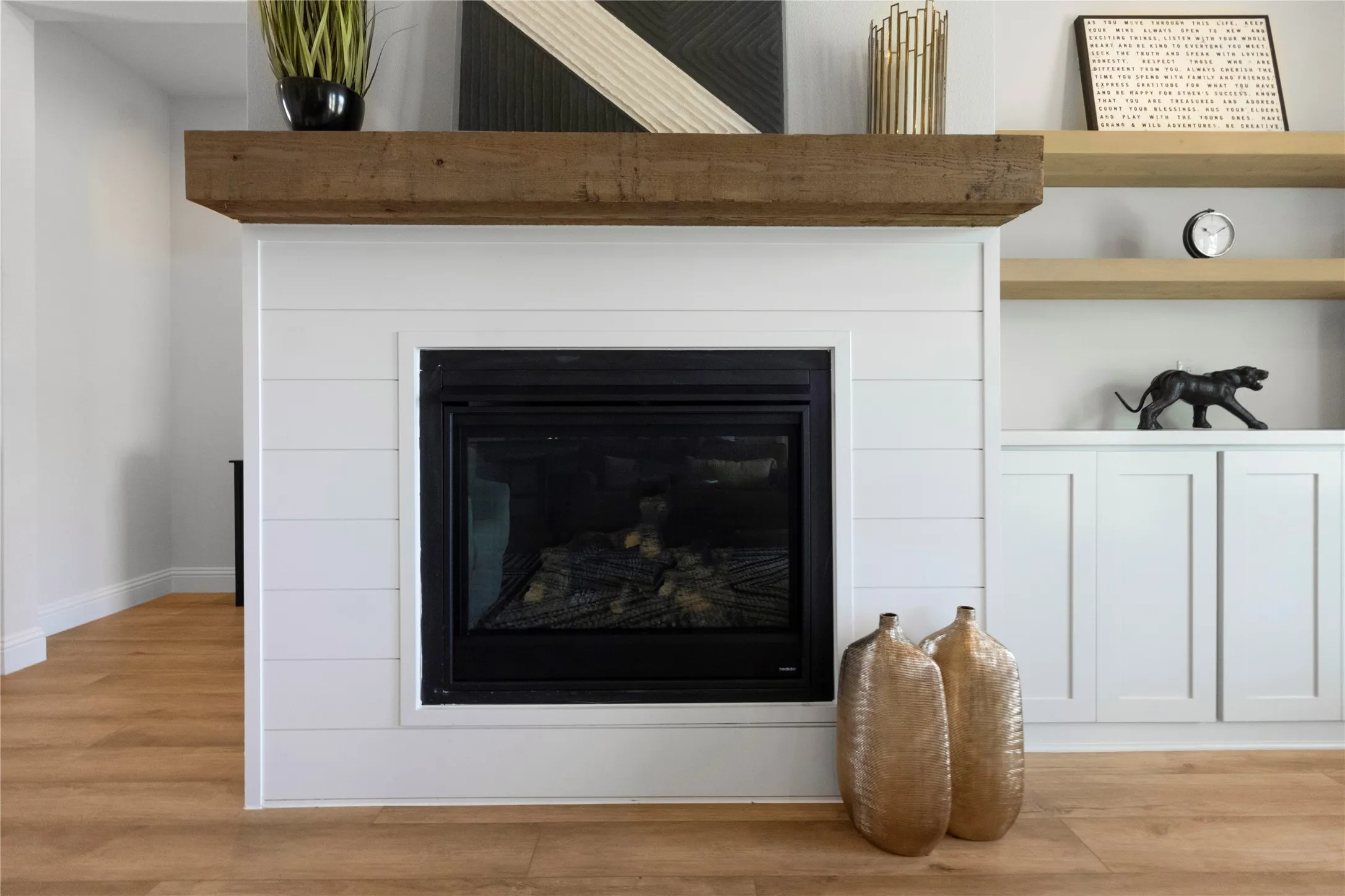 Fireplace with a wood-finish mantel and shiplap-style surround