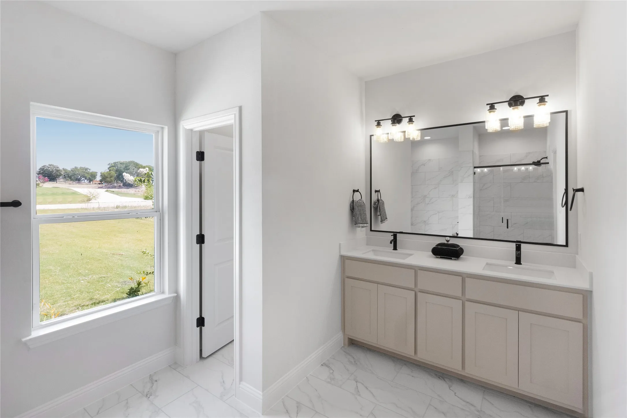 Double vanity with light cabinetry, white countertops, and matte black fixtures