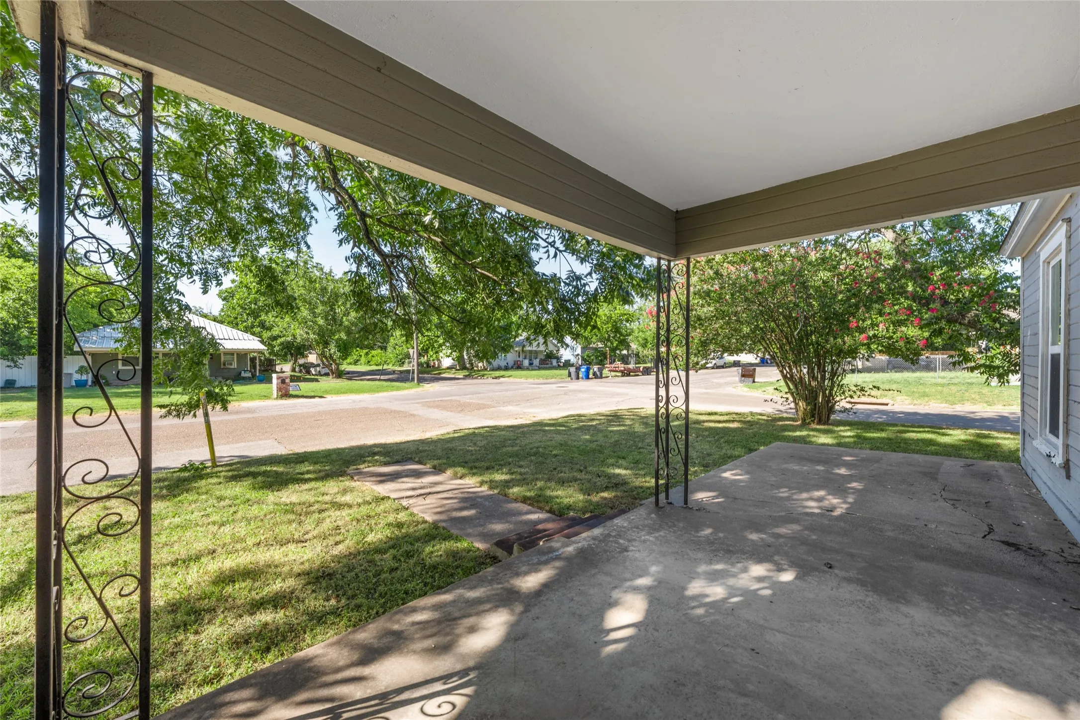 Covered concrete patio with decorative wrought iron columns