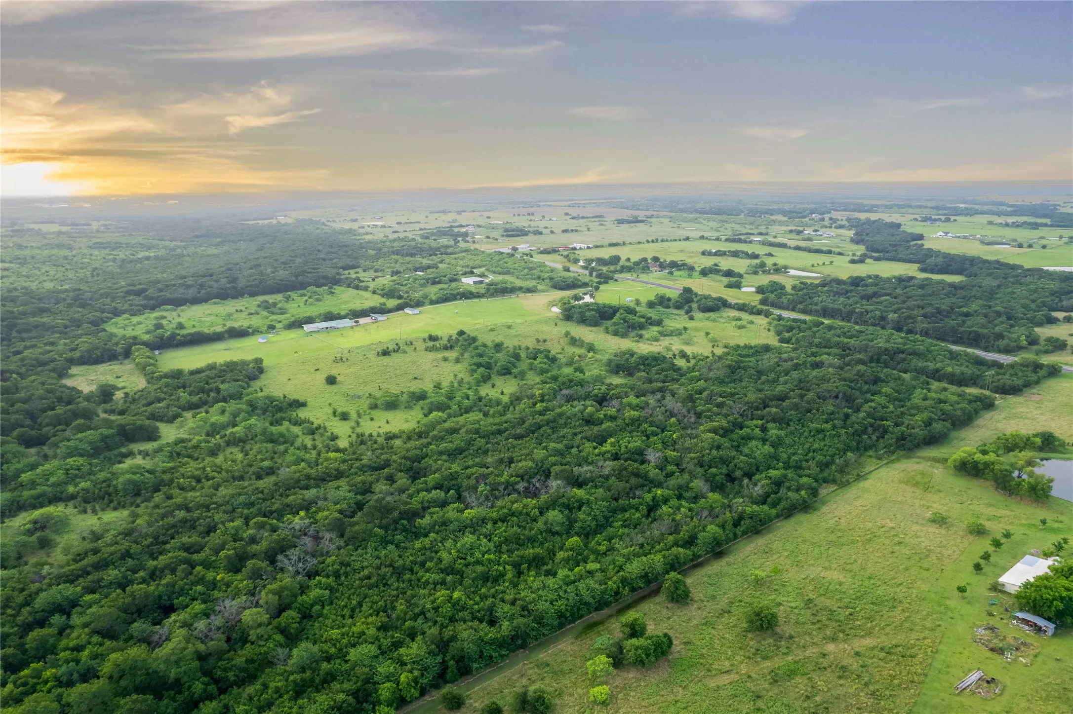 Expansive aerial landscape featuring significant tree coverage and open grassy areas