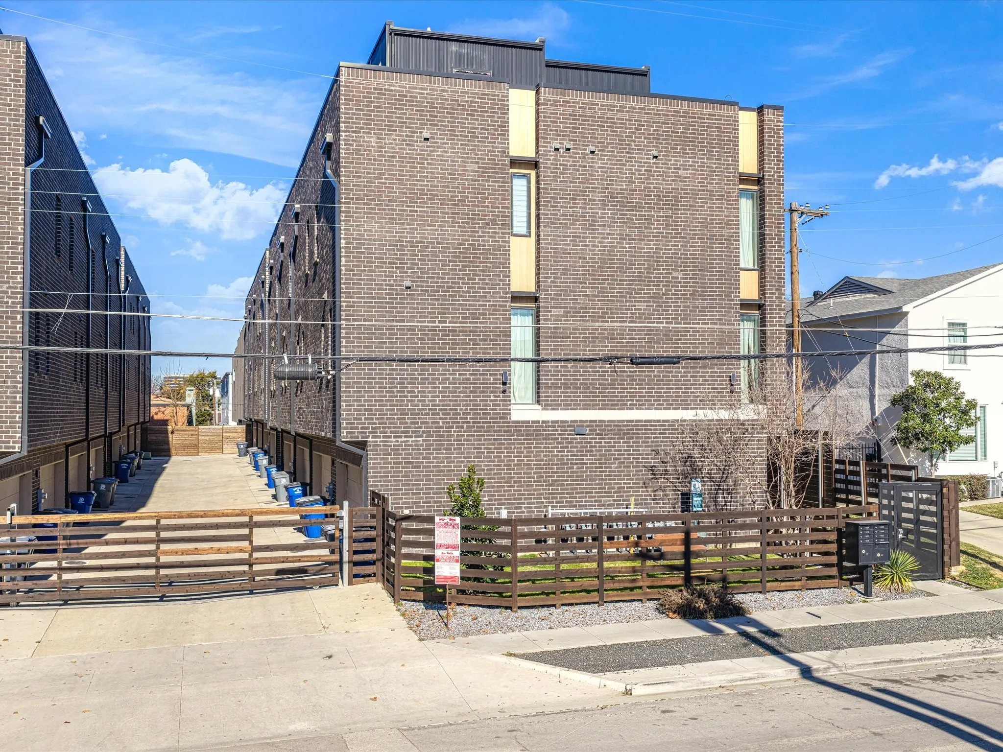 View of side of property featuring brick siding and a fenced front yard