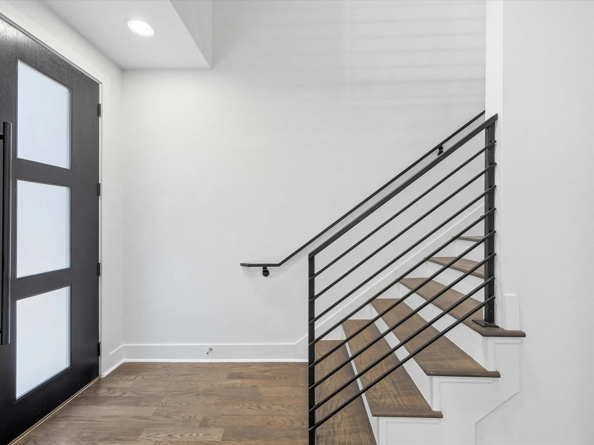 Foyer entrance featuring dark wood finished floors and baseboards