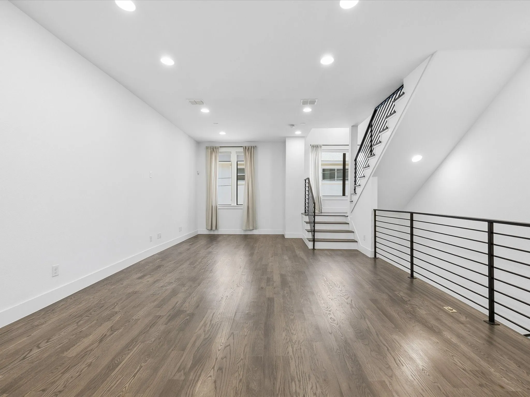 Unfurnished living room with recessed lighting and dark wood-type flooring