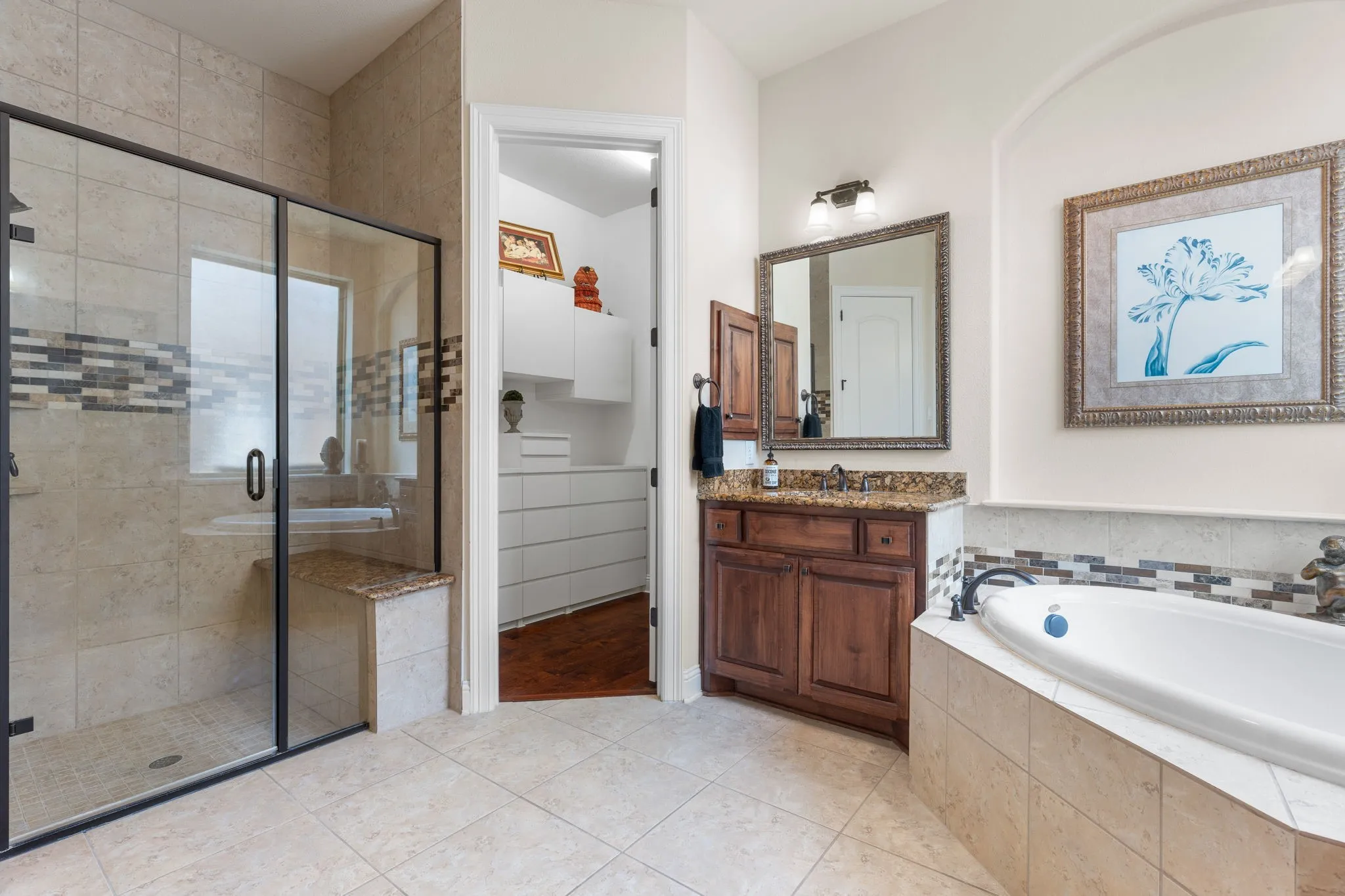 Large shower with bench. Custom Closet has built ins and wood flooring. Impeccable!