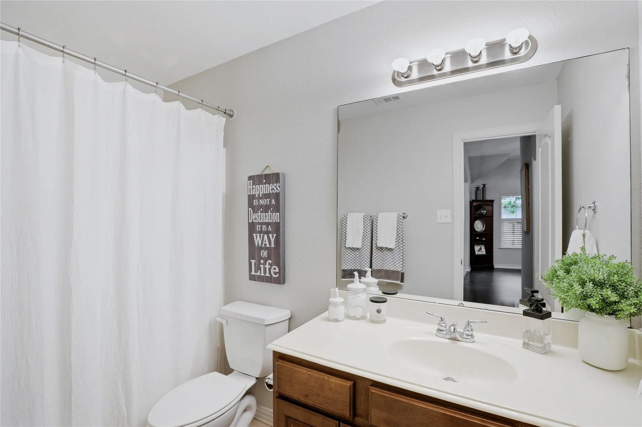 Bathroom vanity featuring a single sink, white countertop, and wood-finish cabinetry
