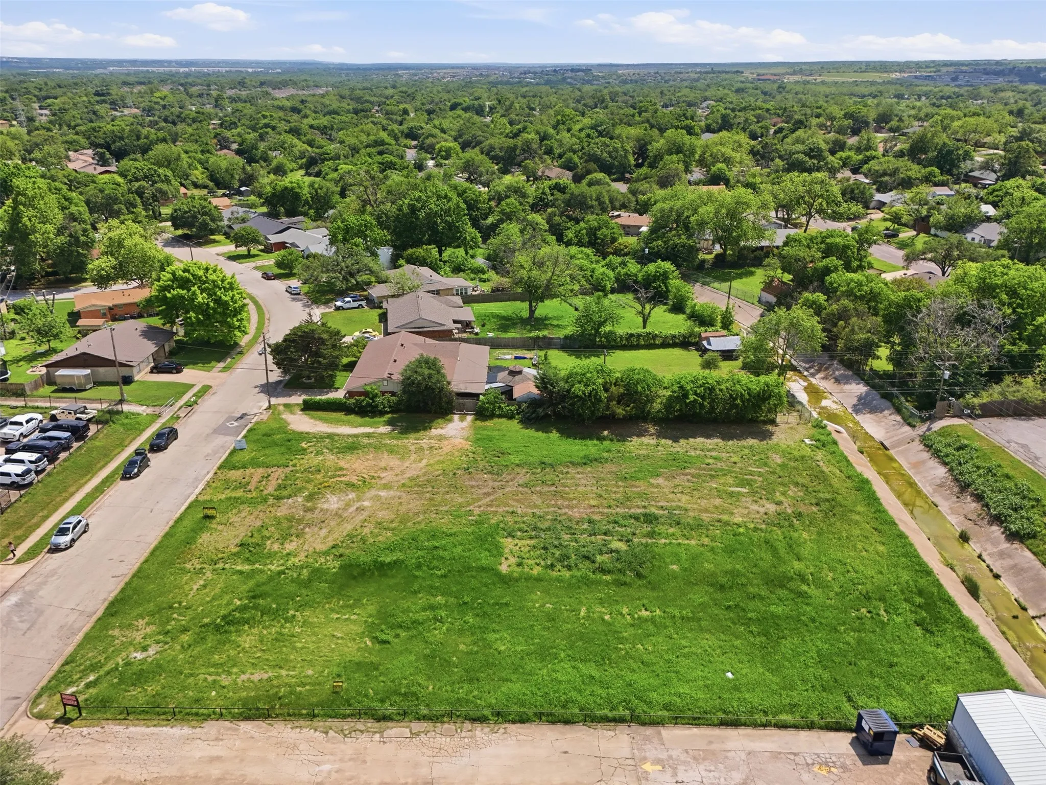 Expansive lot featuring green grass and established trees