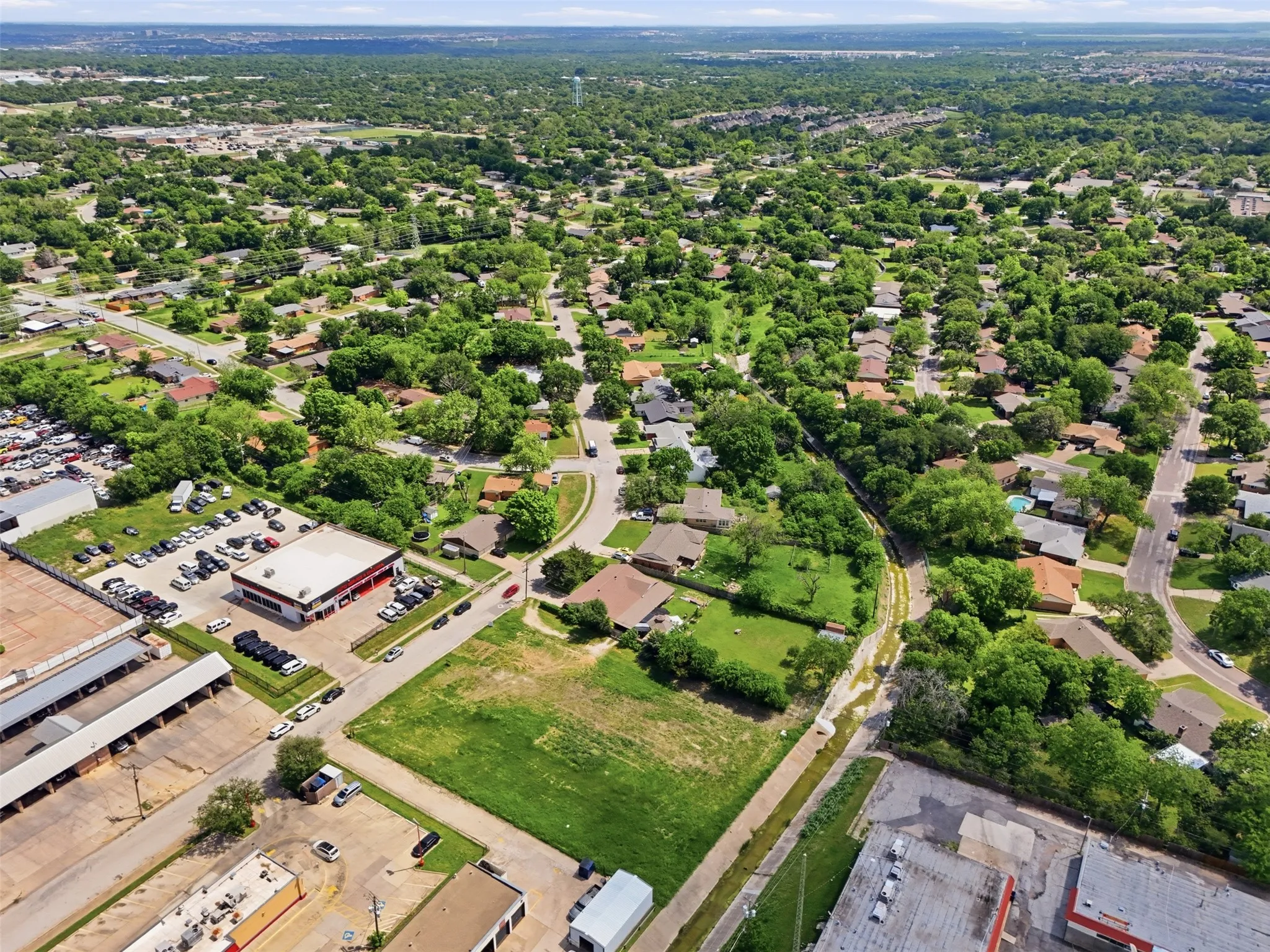 Aerial perspective showcasing a broad expanse of residential development characterized by numerous mature trees