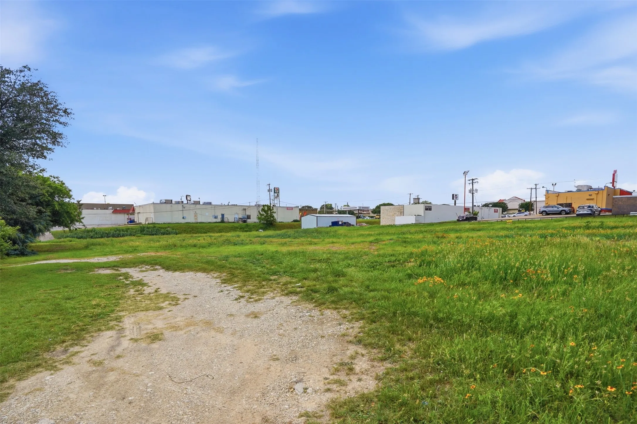 Expansive undeveloped lot featuring a gravel path and natural grass