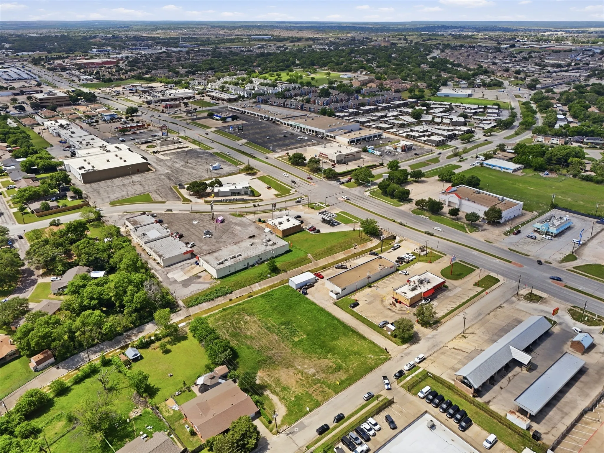Expansive commercial land parcel featuring a grass surface and street-level visibility