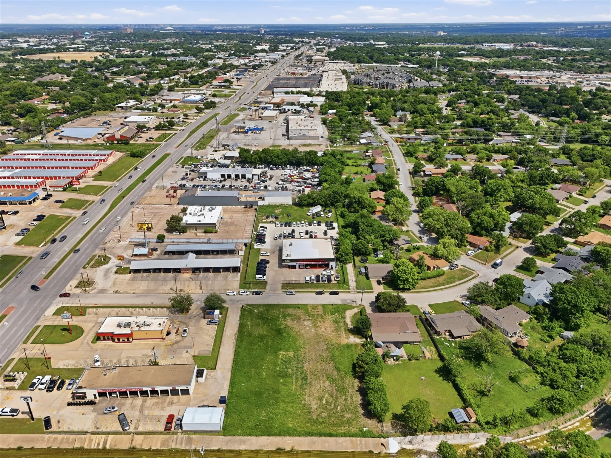 Expansive cleared lot featuring level terrain, direct street frontage, and surrounding commercial and residential properties