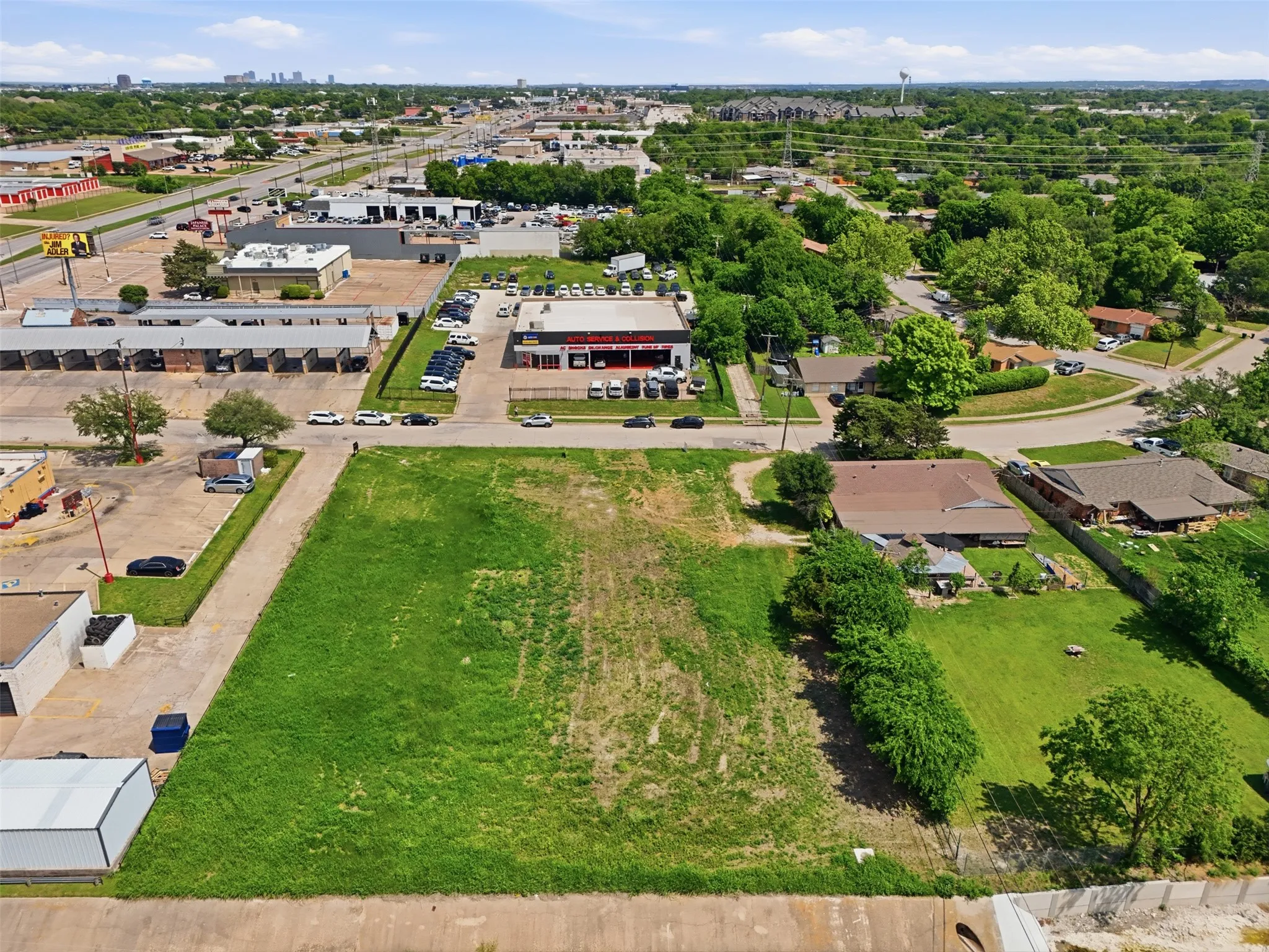 Expansive undeveloped land parcel featuring grass coverage and surrounding mature trees