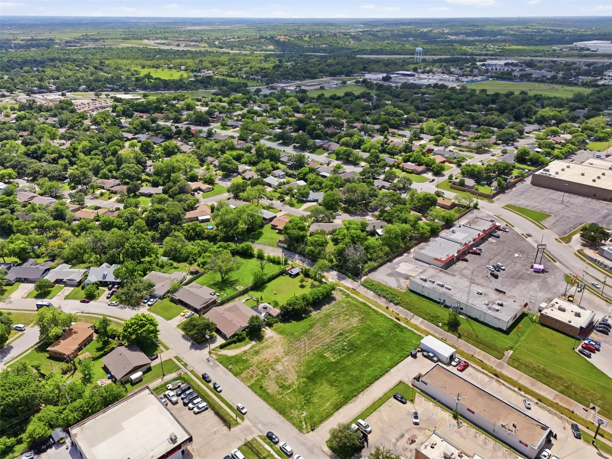 Expansive aerial view showcasing a mixed-use neighborhood with residential properties and commercial buildings