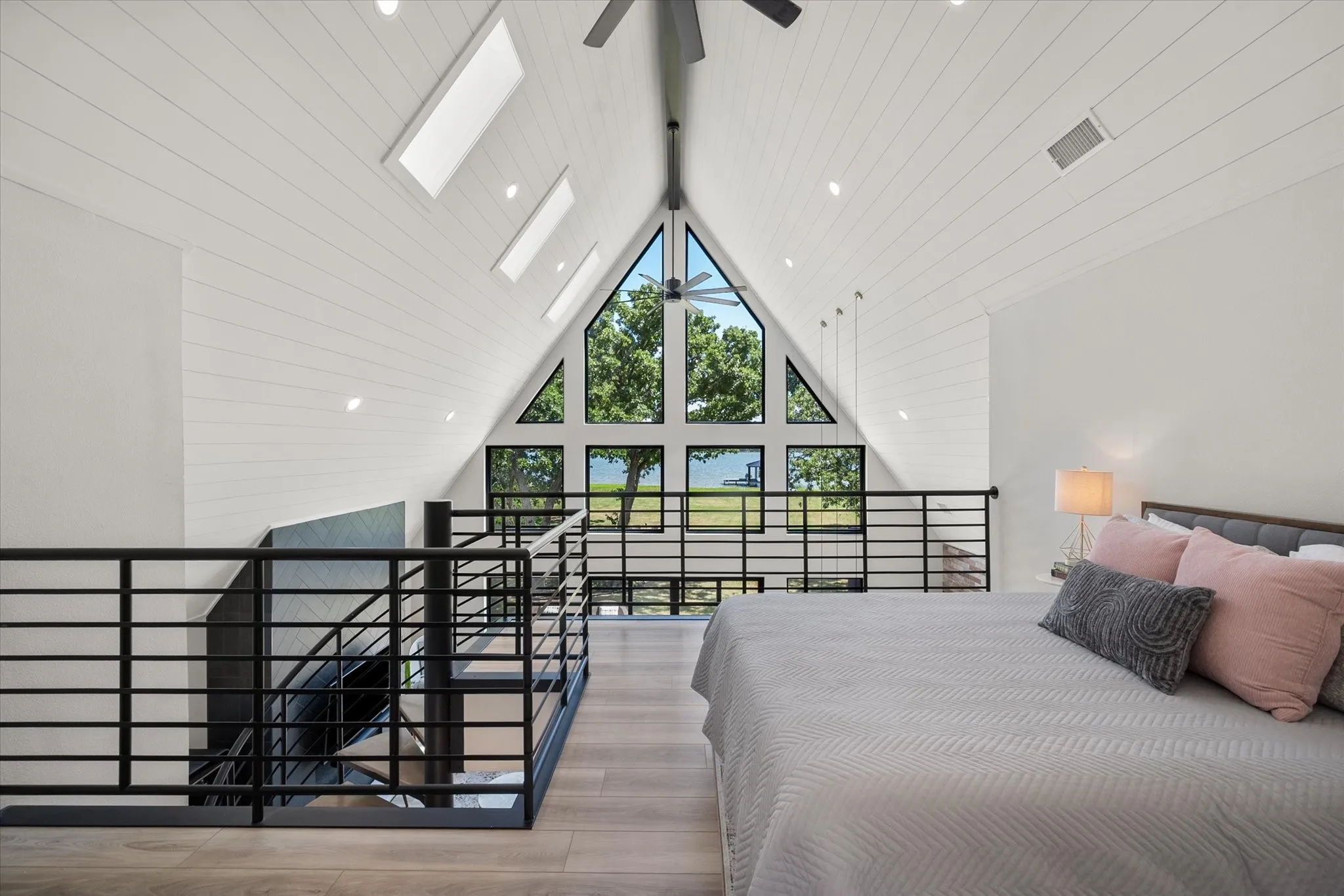 Loft-style primary suite overlooks the dramatic two-story great room below.