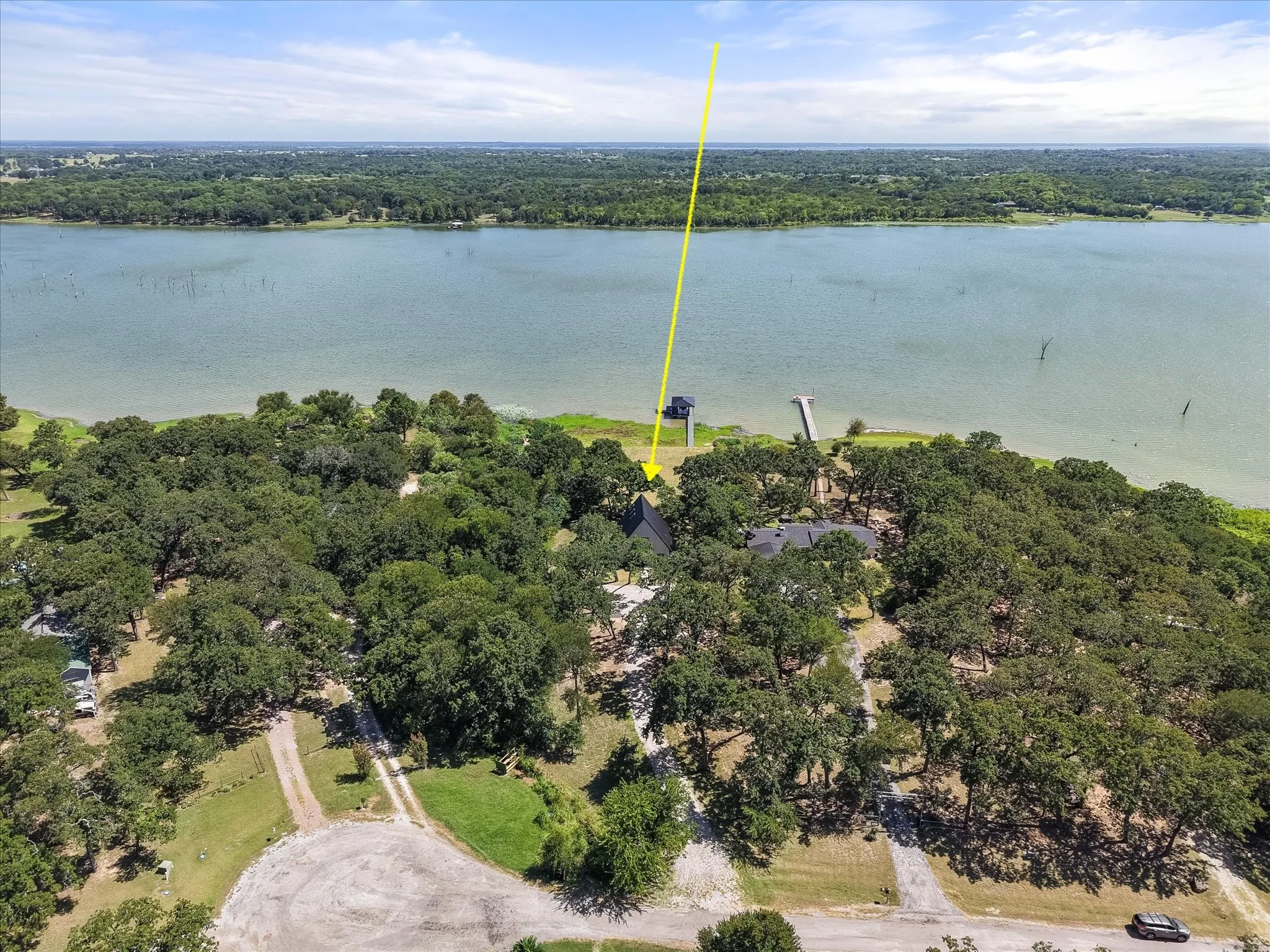 Bird's-eye view showcasing the home's private waterfront setting surrounded by mature shade trees.