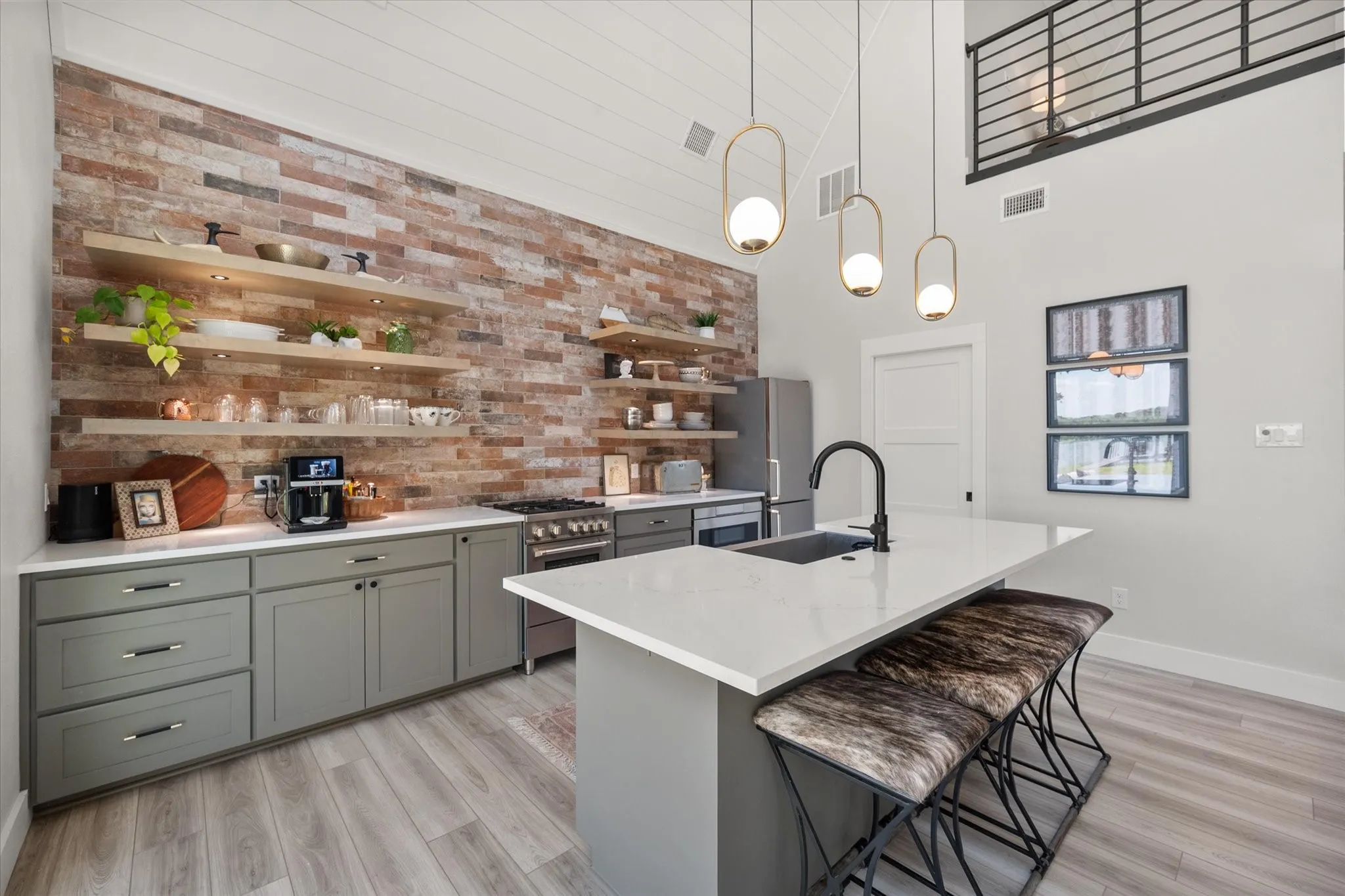 Open shelving and designer lighting create a warm, custom feel throughout the kitchen.