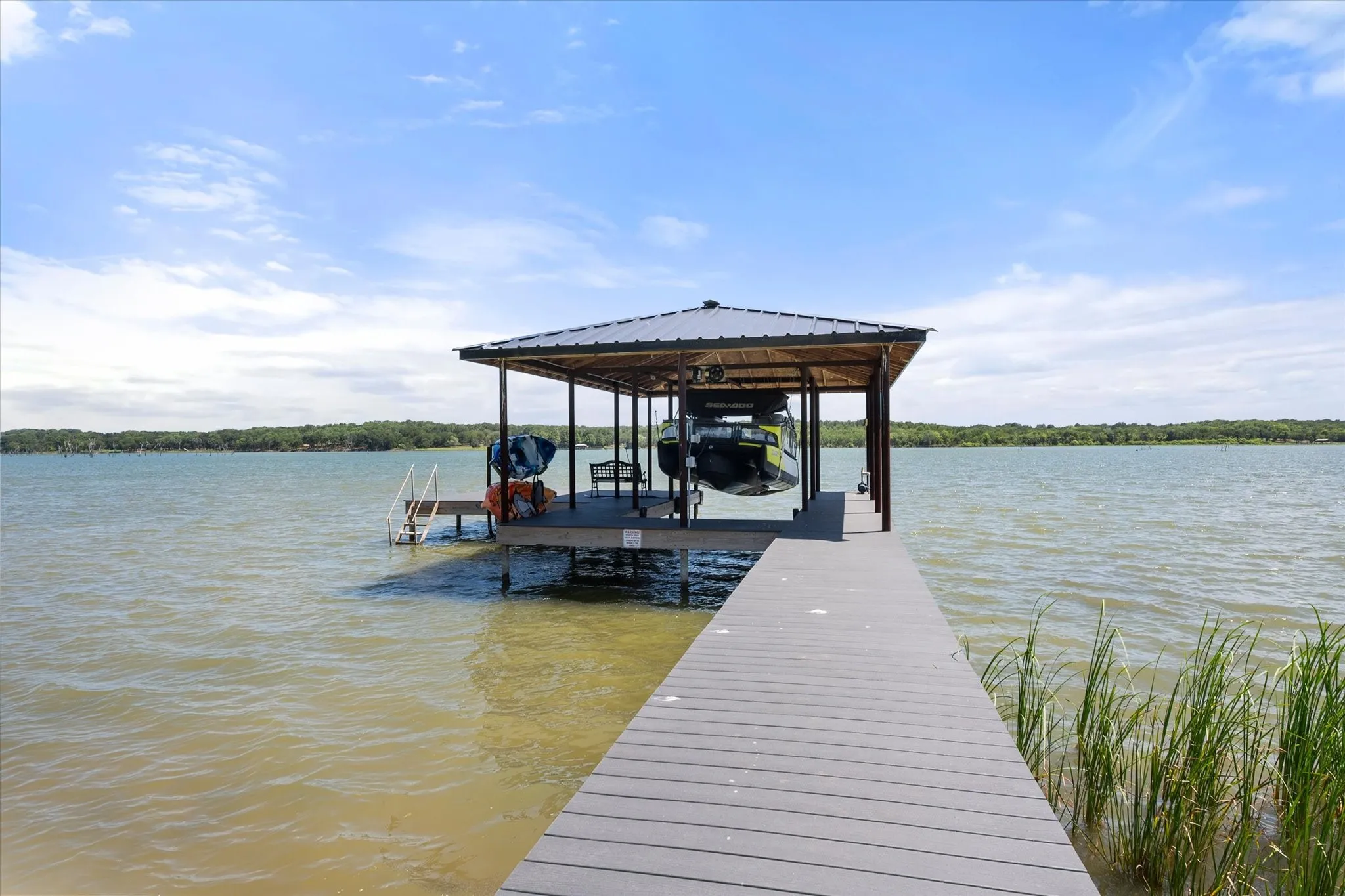 Covered TREX boathouse with boat lift offers easy access to boating, fishing, and lake adventures.