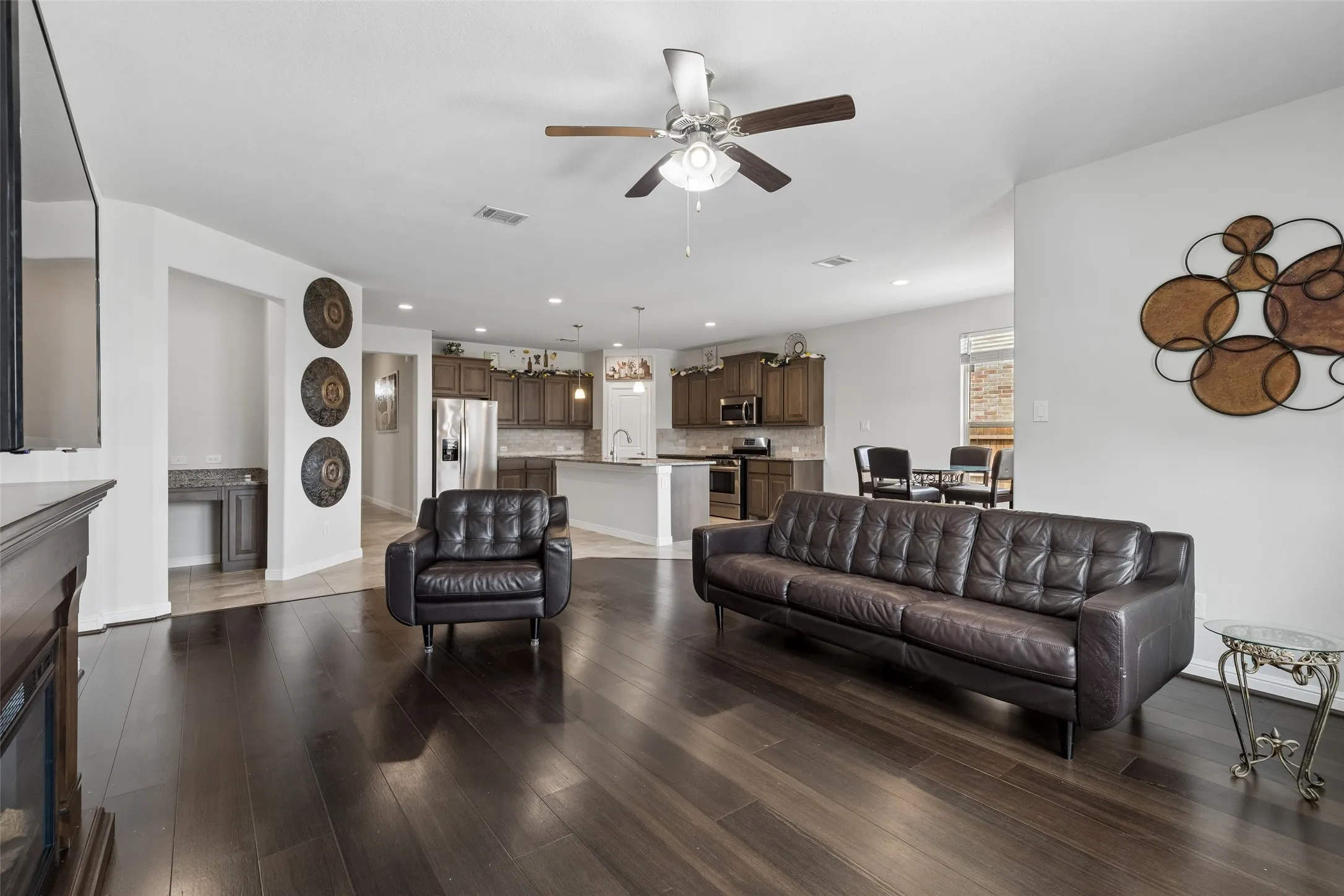 Spacious Living area with ceiling fan, decorative fireplace and TV with mount.