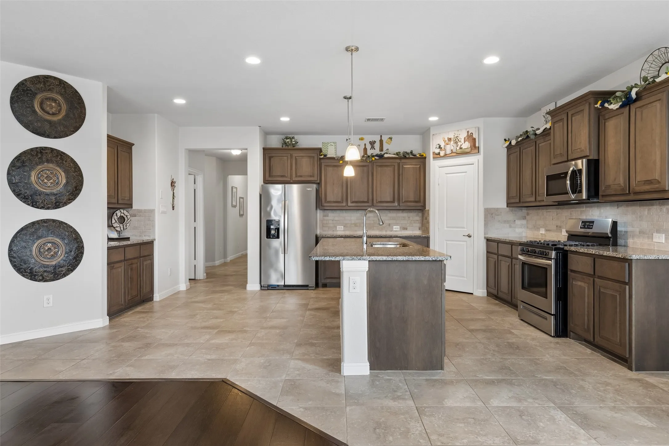 Large kitchen area with gas cooktop & SS appliances including the refrigerator.