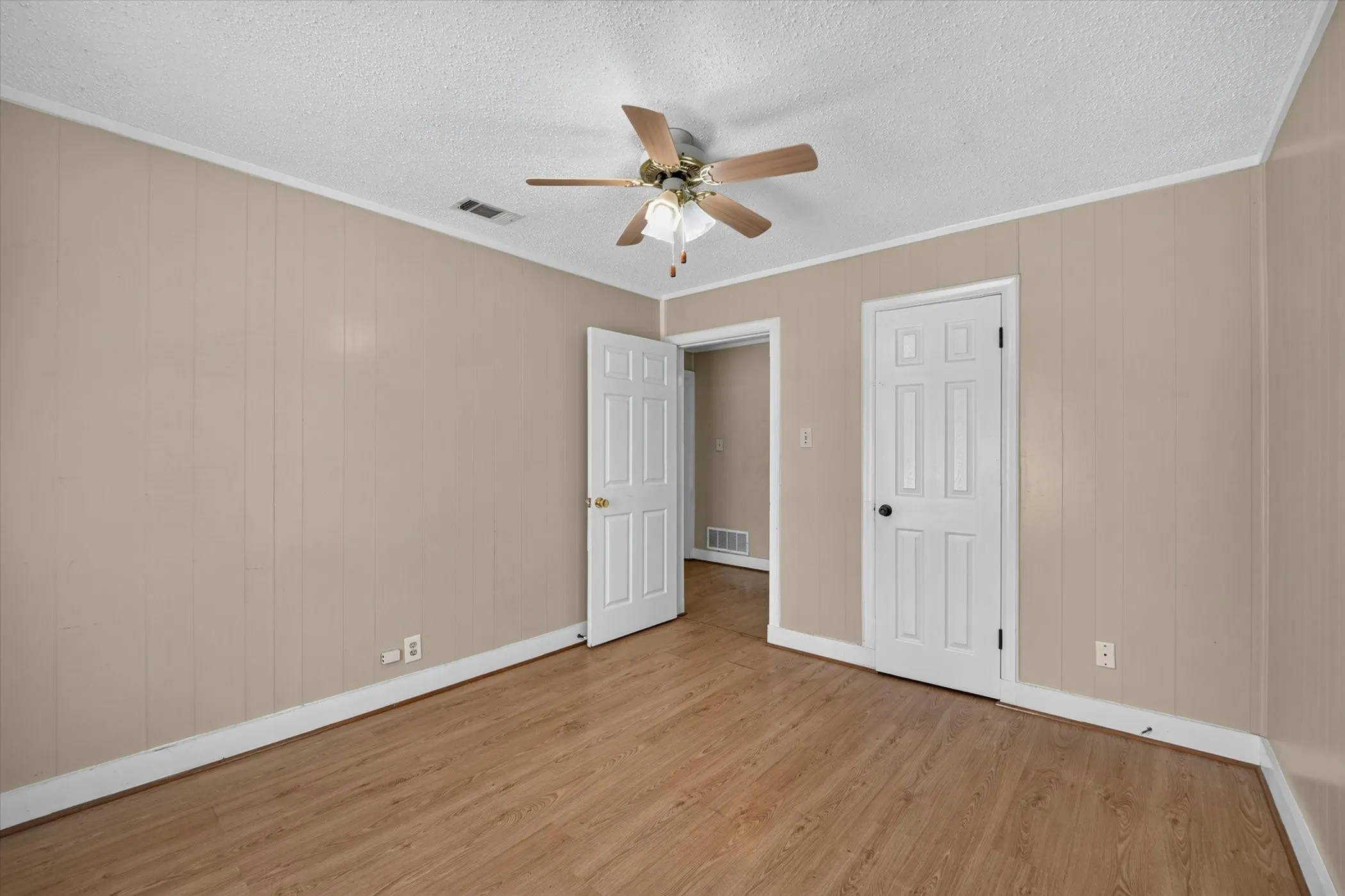 Room featuring light wood-finish flooring and paneled walls