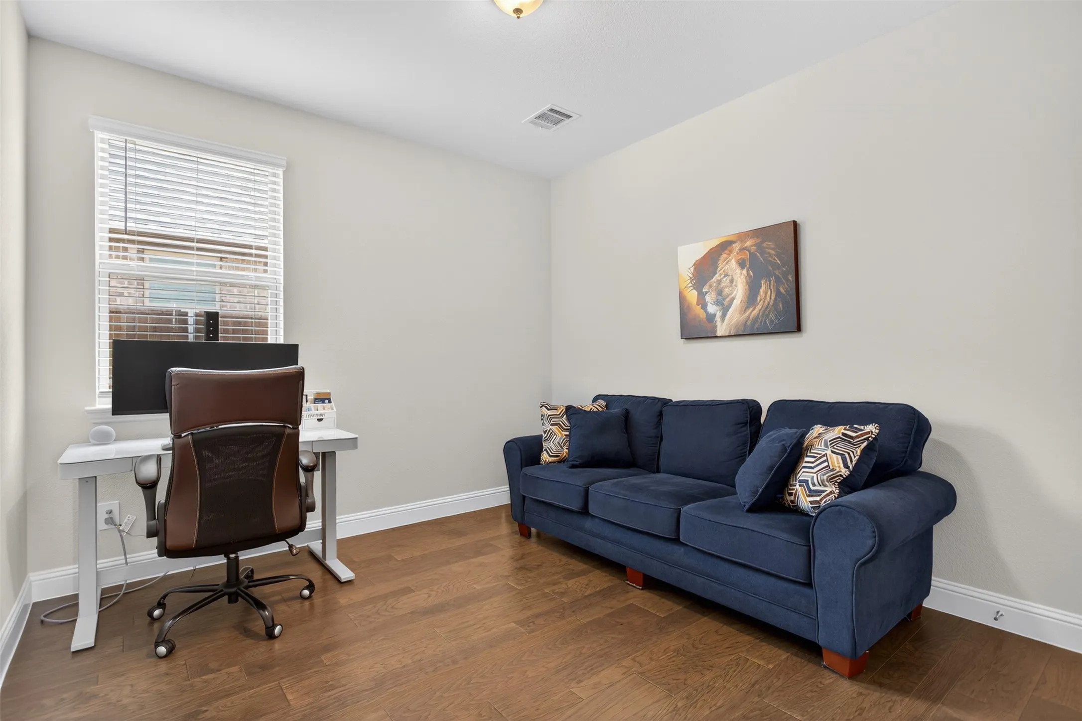 Versatile room featuring wood-finish flooring, light-toned wall paint, and white trim molding