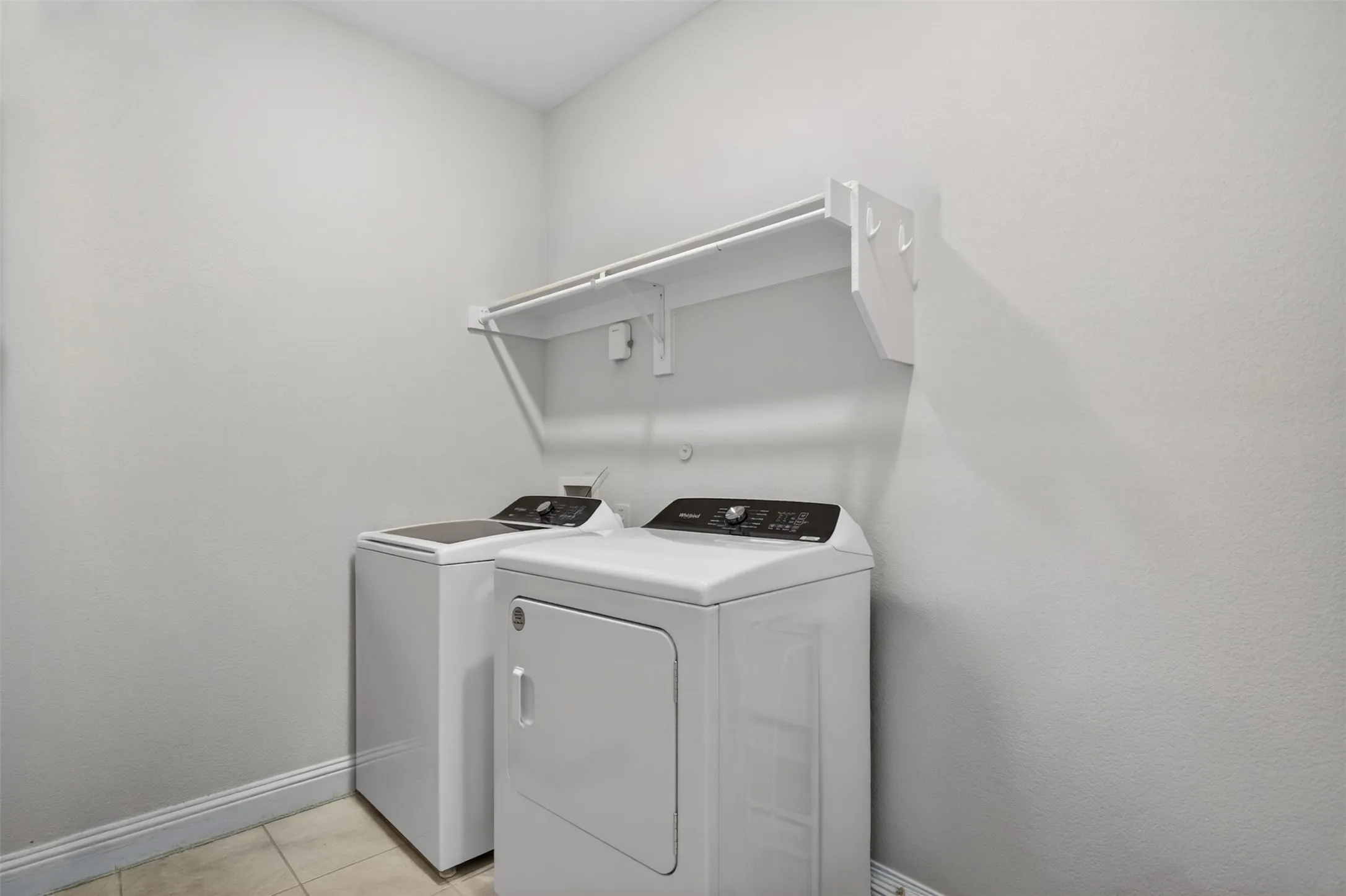 Dedicated laundry area featuring a white top-load washing machine and front-load dryer
