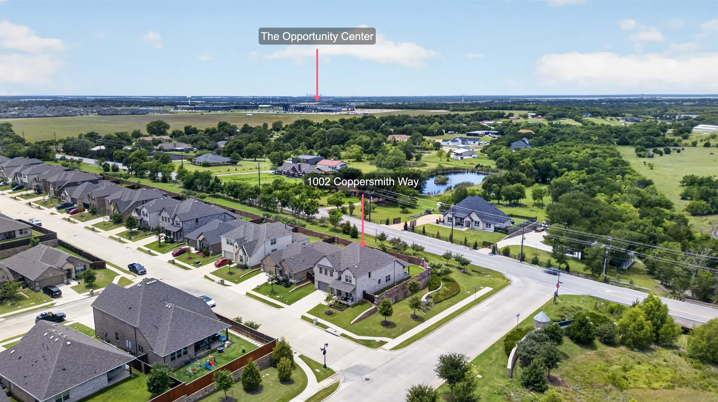 Aerial perspective of a suburban neighborhood featuring residential properties with manicured lawns and paved streets