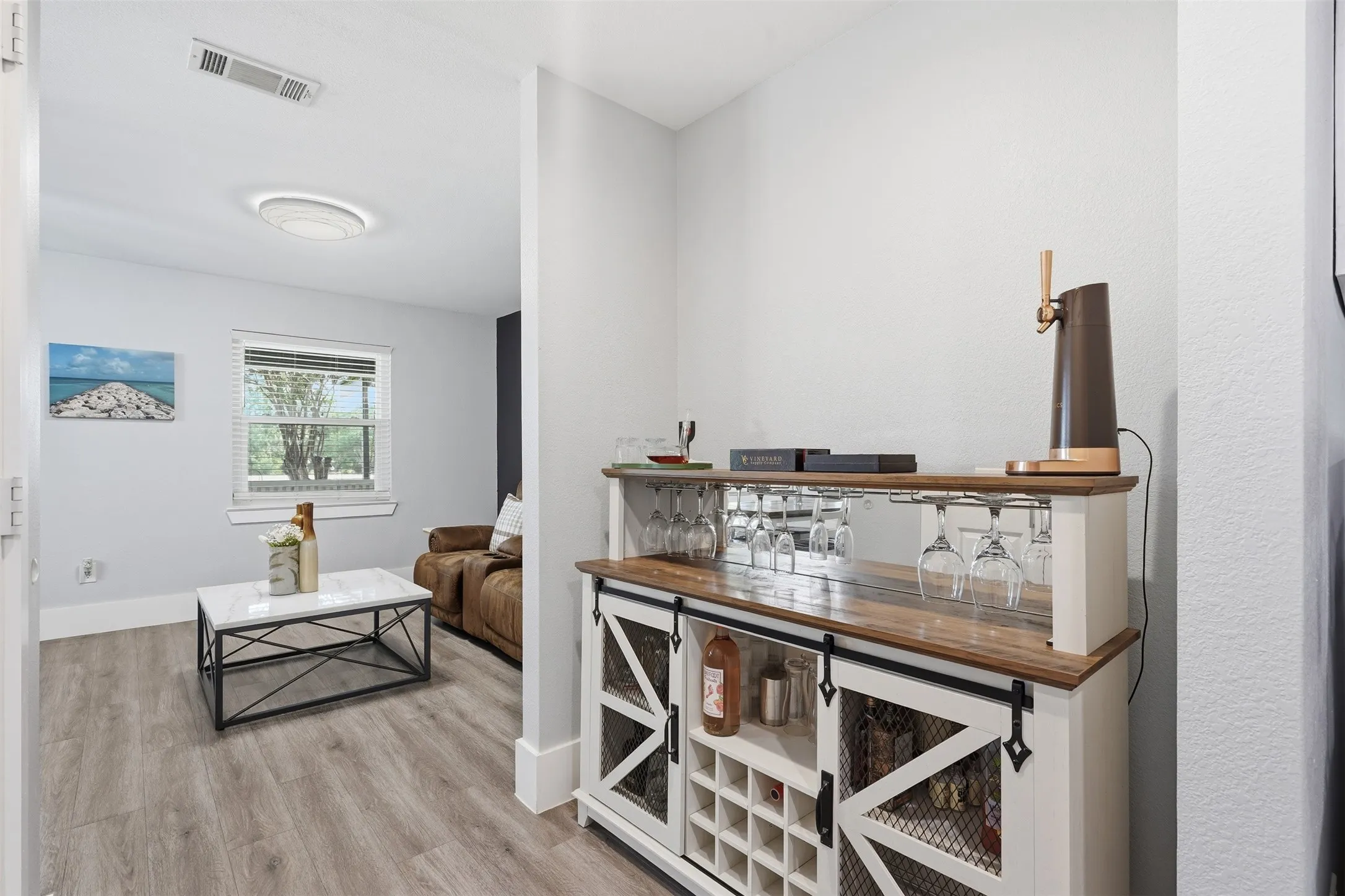 Built-in bar cabinet with mirrored backsplash, integrated wine rack, and wood-finish countertop