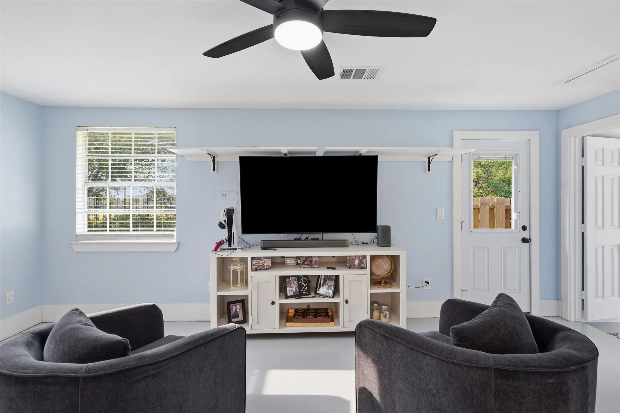 Spacious room featuring light blue walls, a white trim package, and light-toned flooring