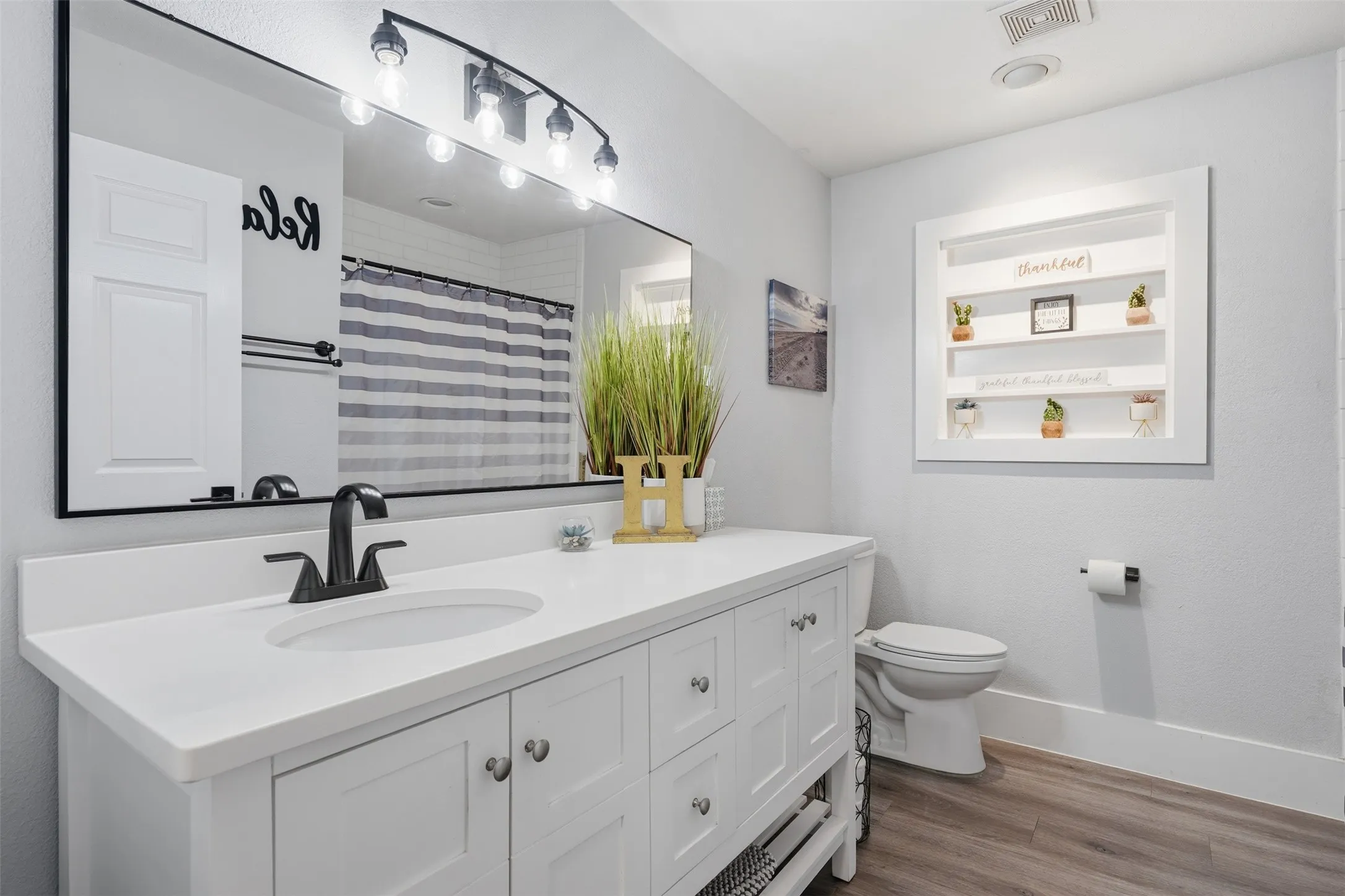 White vanity with an integrated sink, matte black faucet, and coordinating hardware