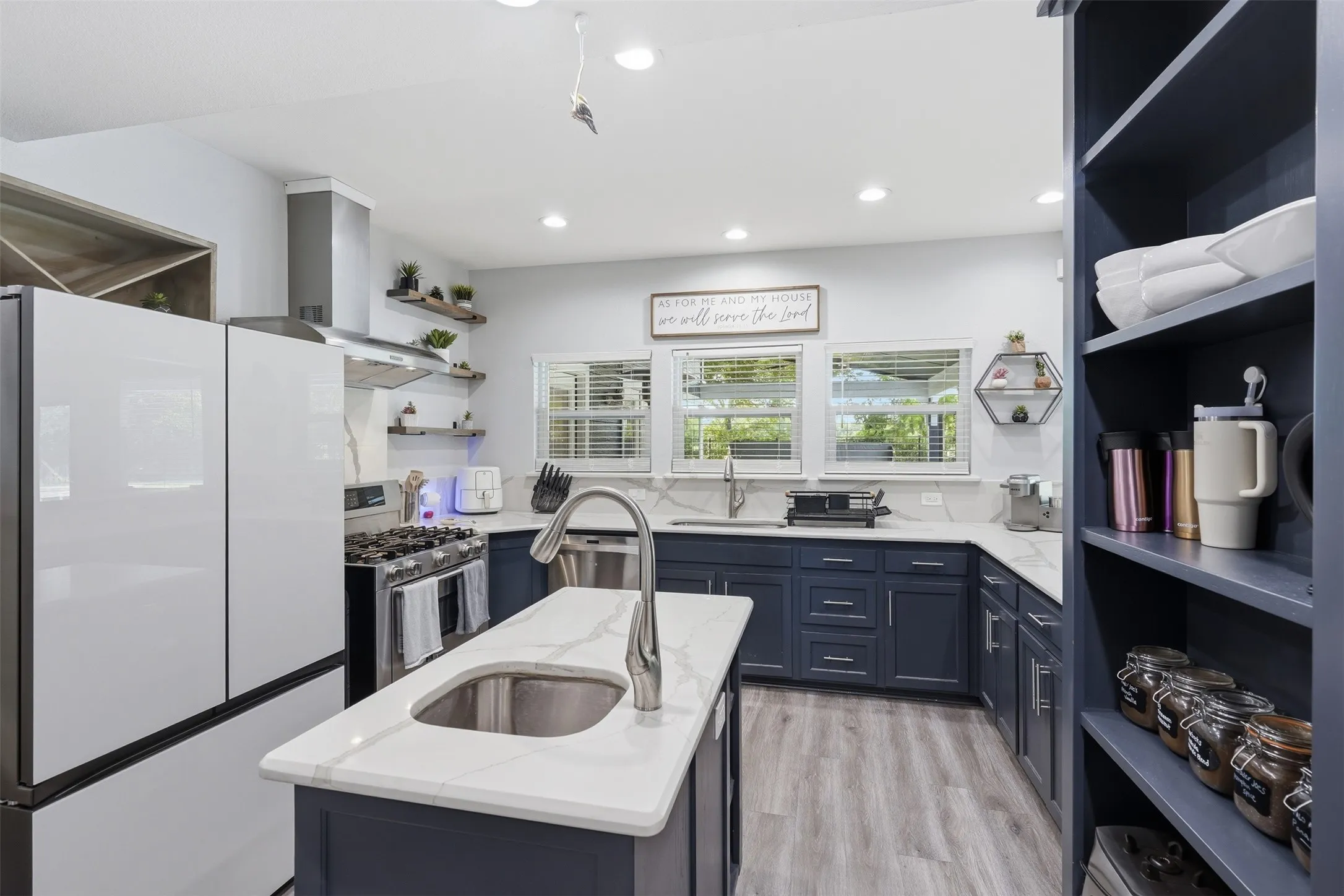 Kitchen featuring a central island with an undermount sink and a gooseneck faucet