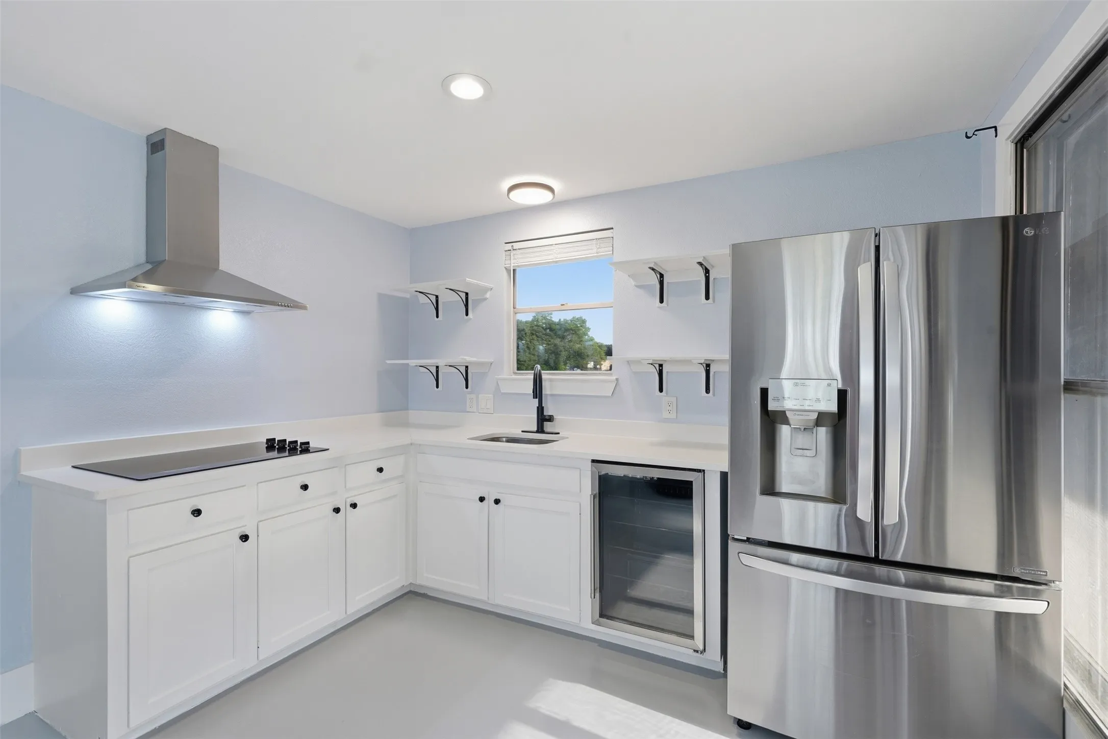 Kitchen featuring white cabinetry, light countertops, and light blue walls
