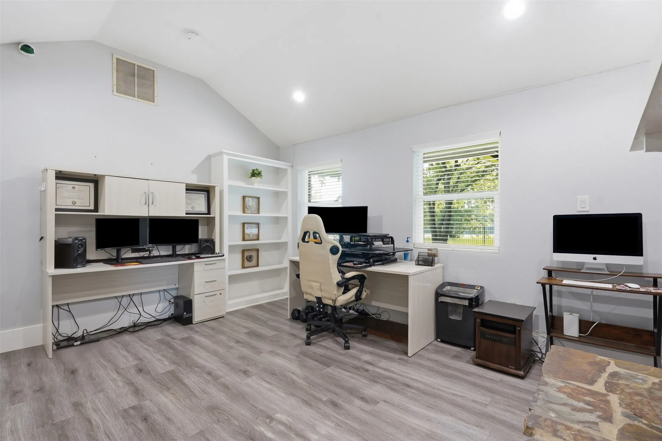 Versatile room featuring wood-finish flooring, vaulted ceilings, and recessed lighting
