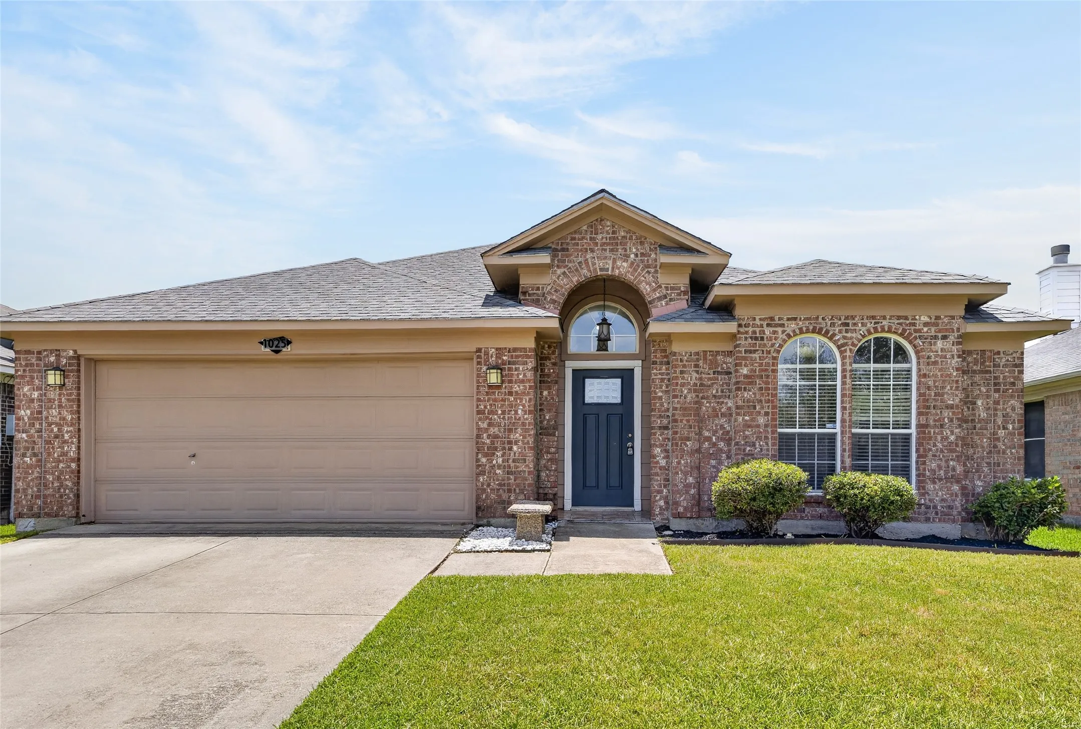 Brick exterior with arched entry, complementing arched windows, and a two-car​​‌​​​​‌​​‌‌​‌‌​​​‌‌​‌​‌​‌​​​‌​​ garage