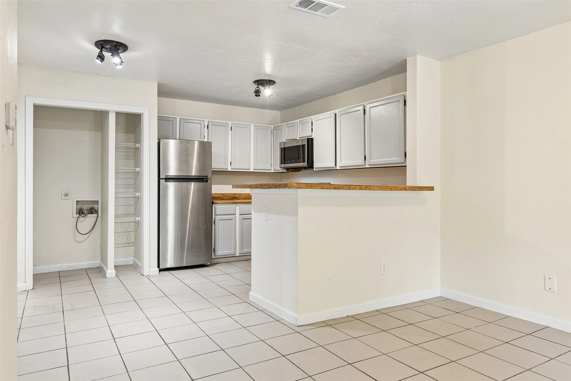 Kitchen area with tile flooring and track lighting